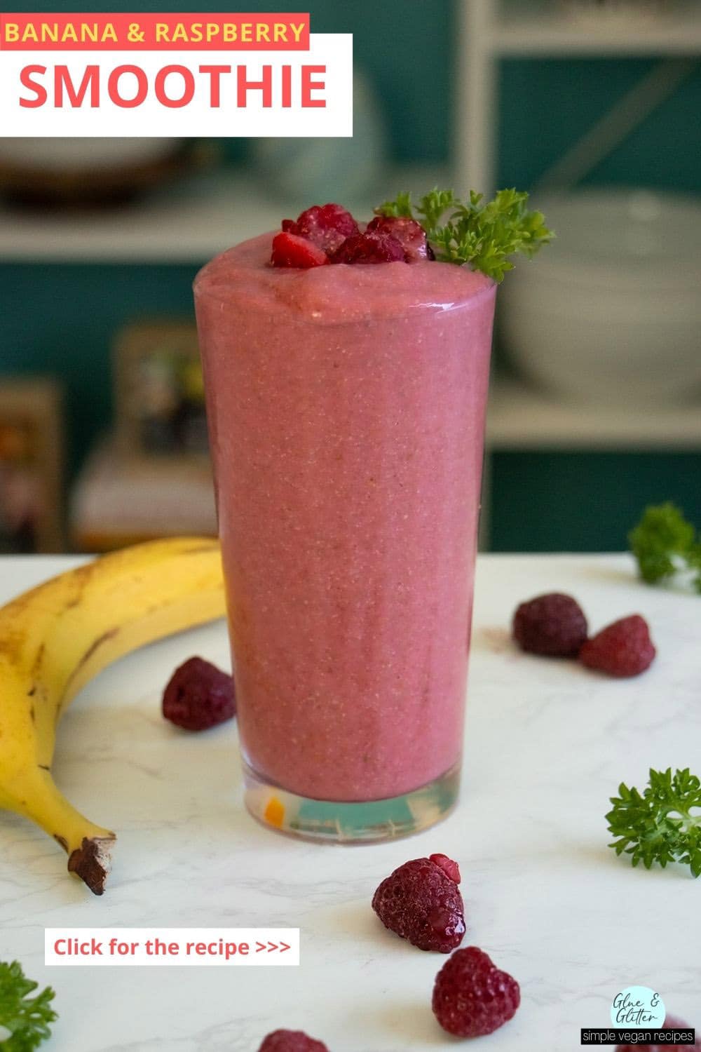 banana and raspberry smoothie in a glass on a white table surrounded by fruit and parsley, text overlay