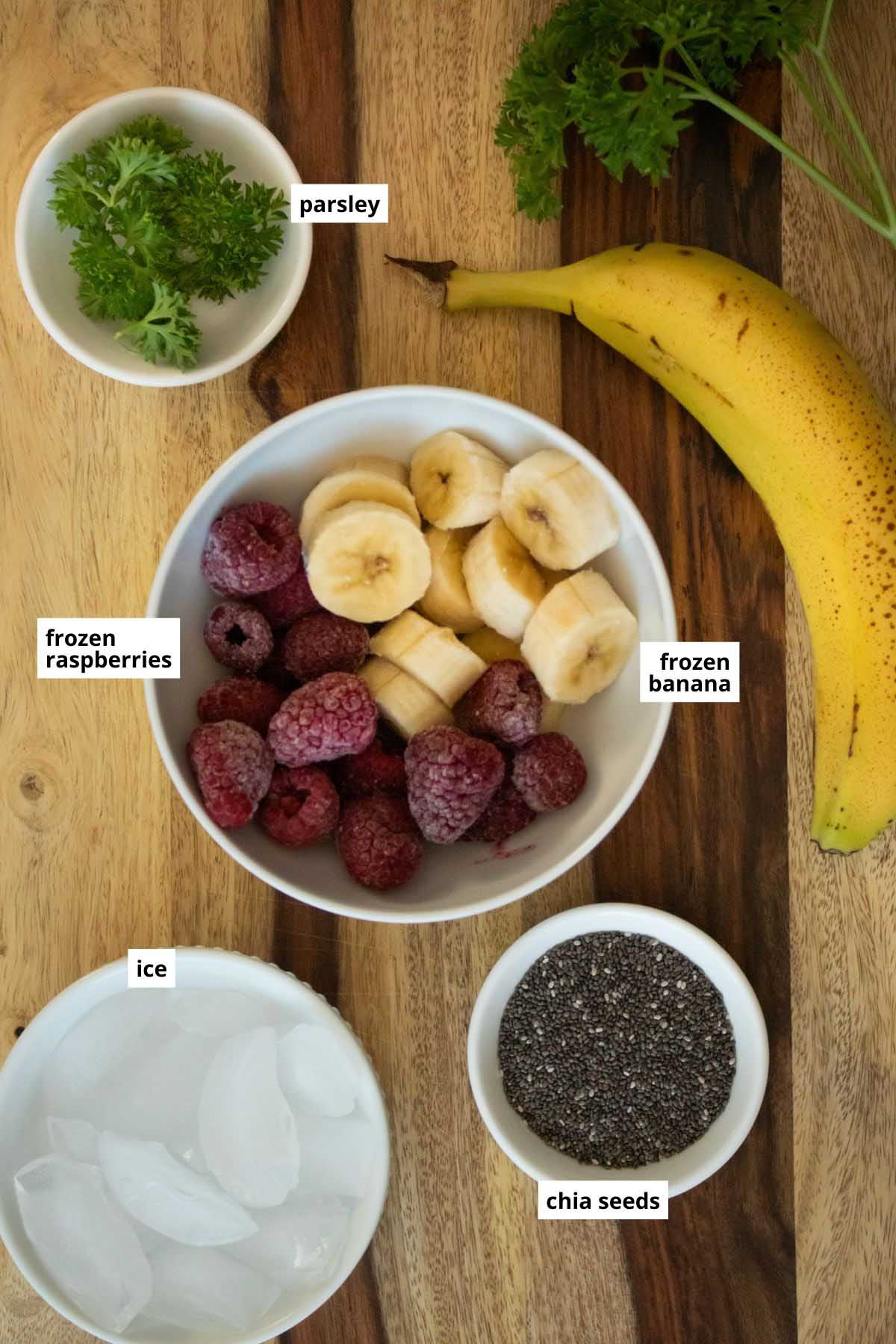 raspberry banana smoothie ingredients in bowls on a wooden table