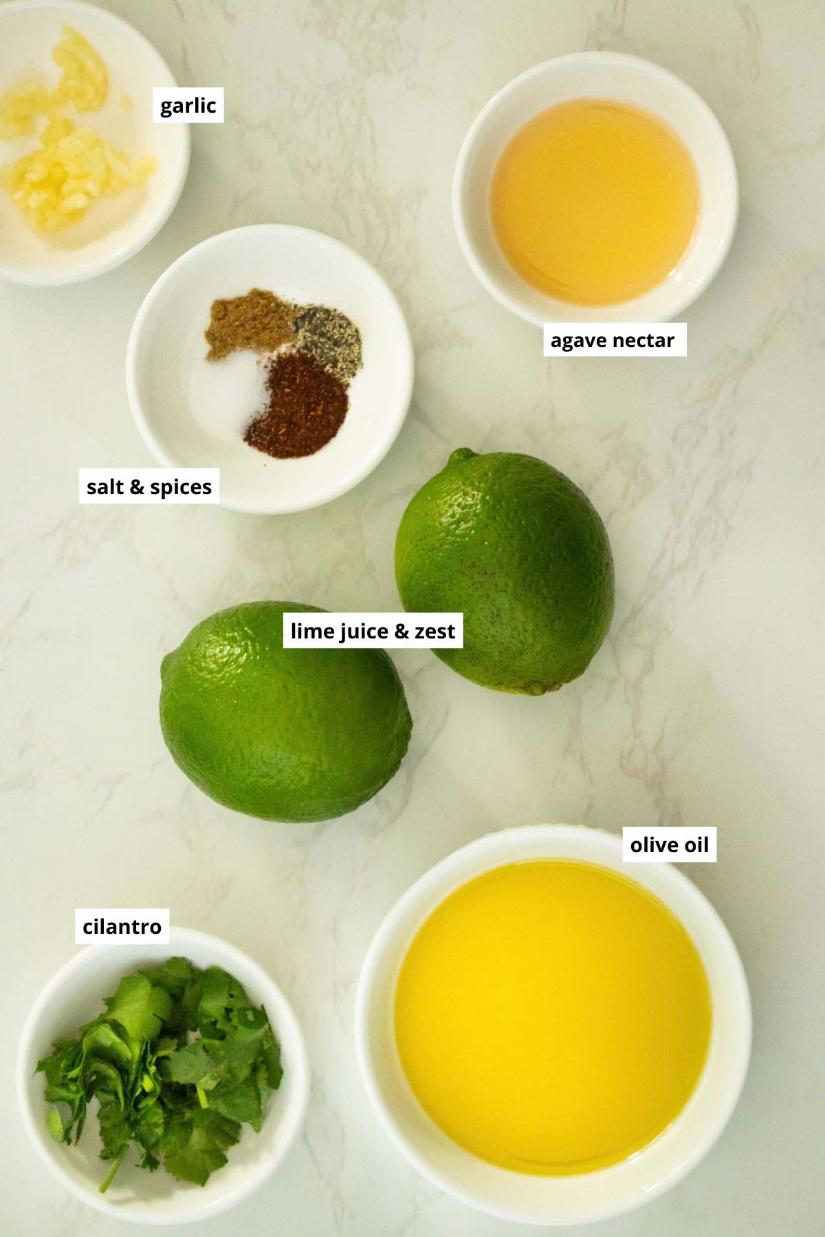 limes, spices, and other chipotle lime dressing ingredients on a white table