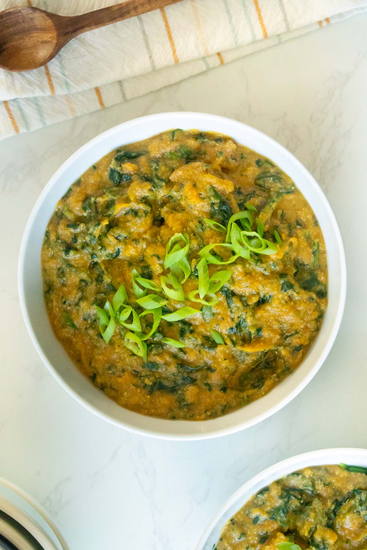 instant pot sweet potato lentil soup in a bowl topped with green onion