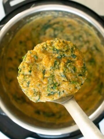 close-up of a ladle serving sweet potato lentil soup from the instant pot