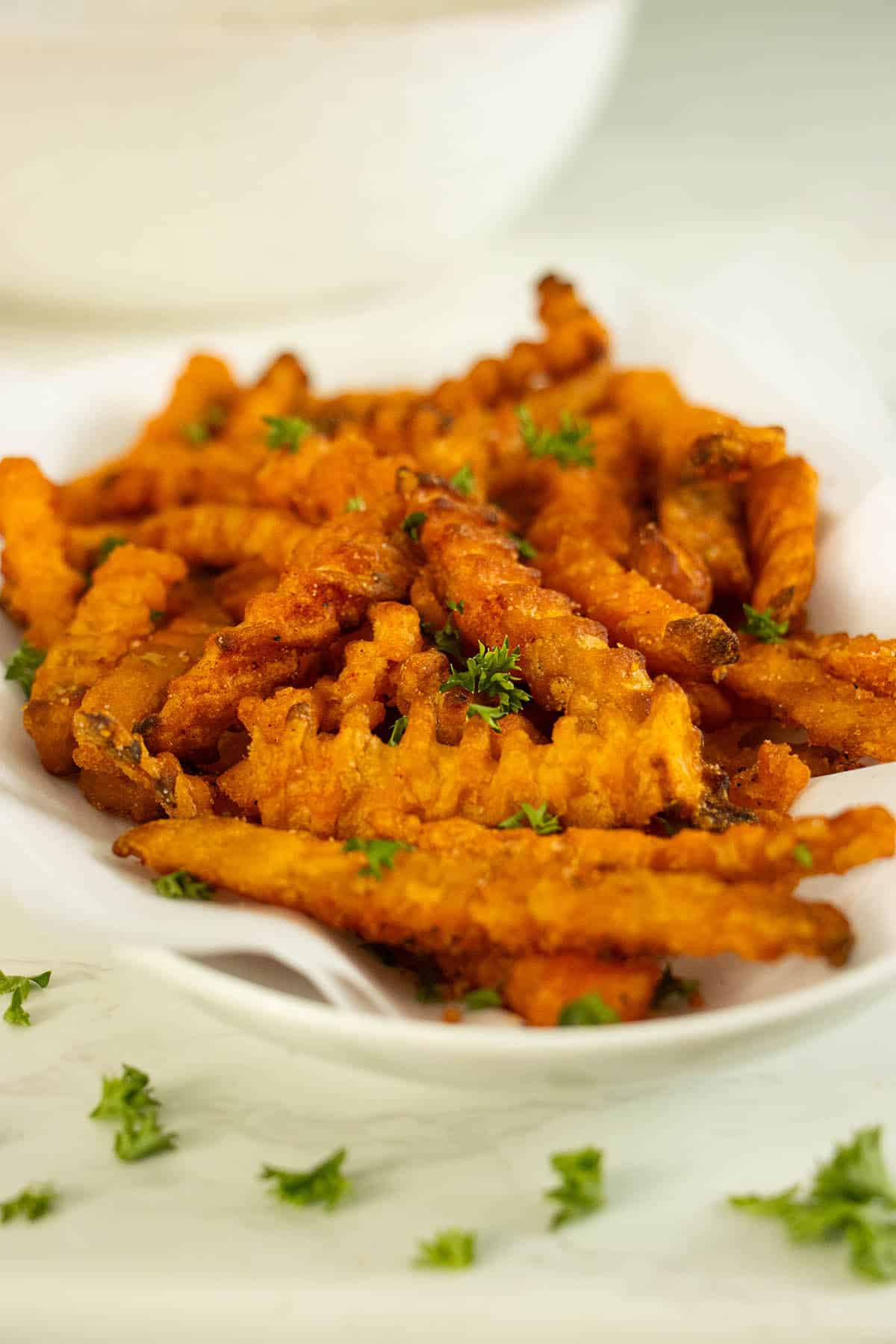 air fryer frozen sweet potato fries on a serving tray after cooking and seasoning
