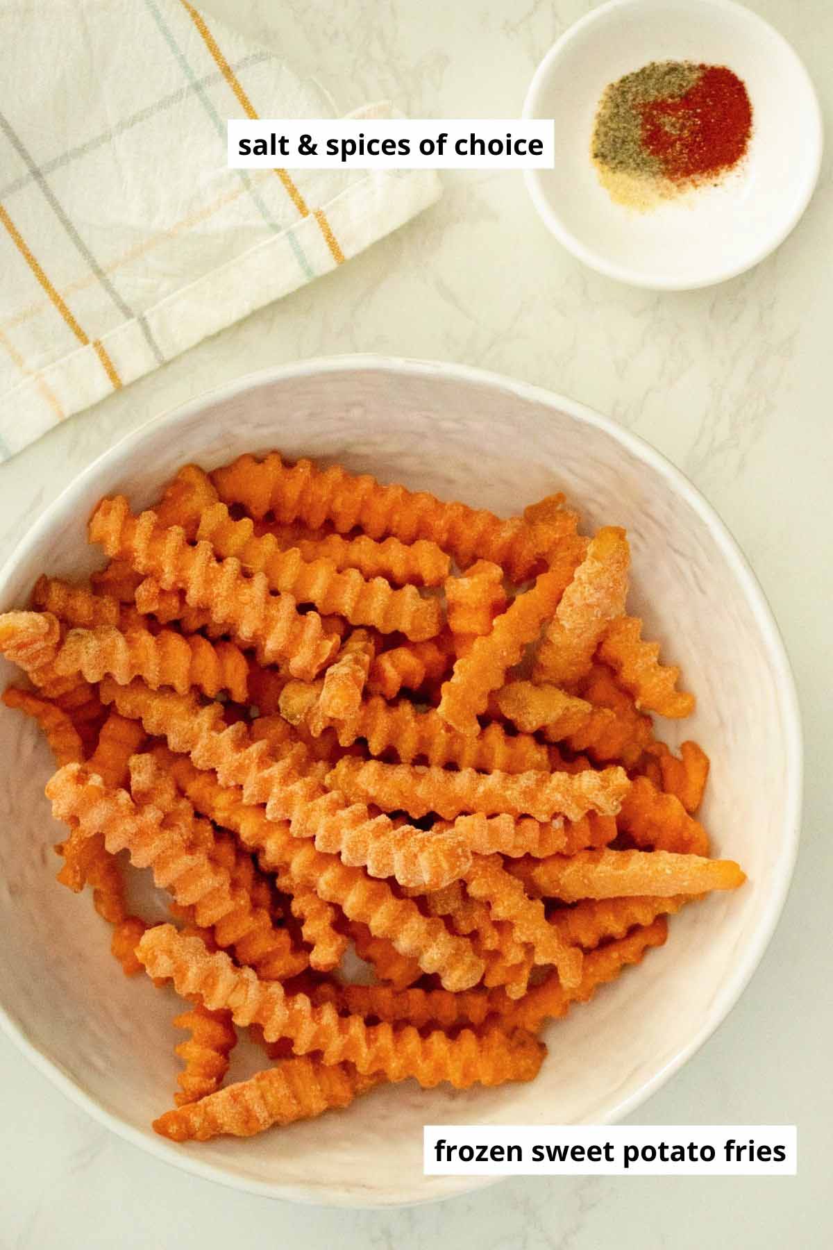 frozen sweet potato fries in a bowl next to a ramekin with salt and spices in it