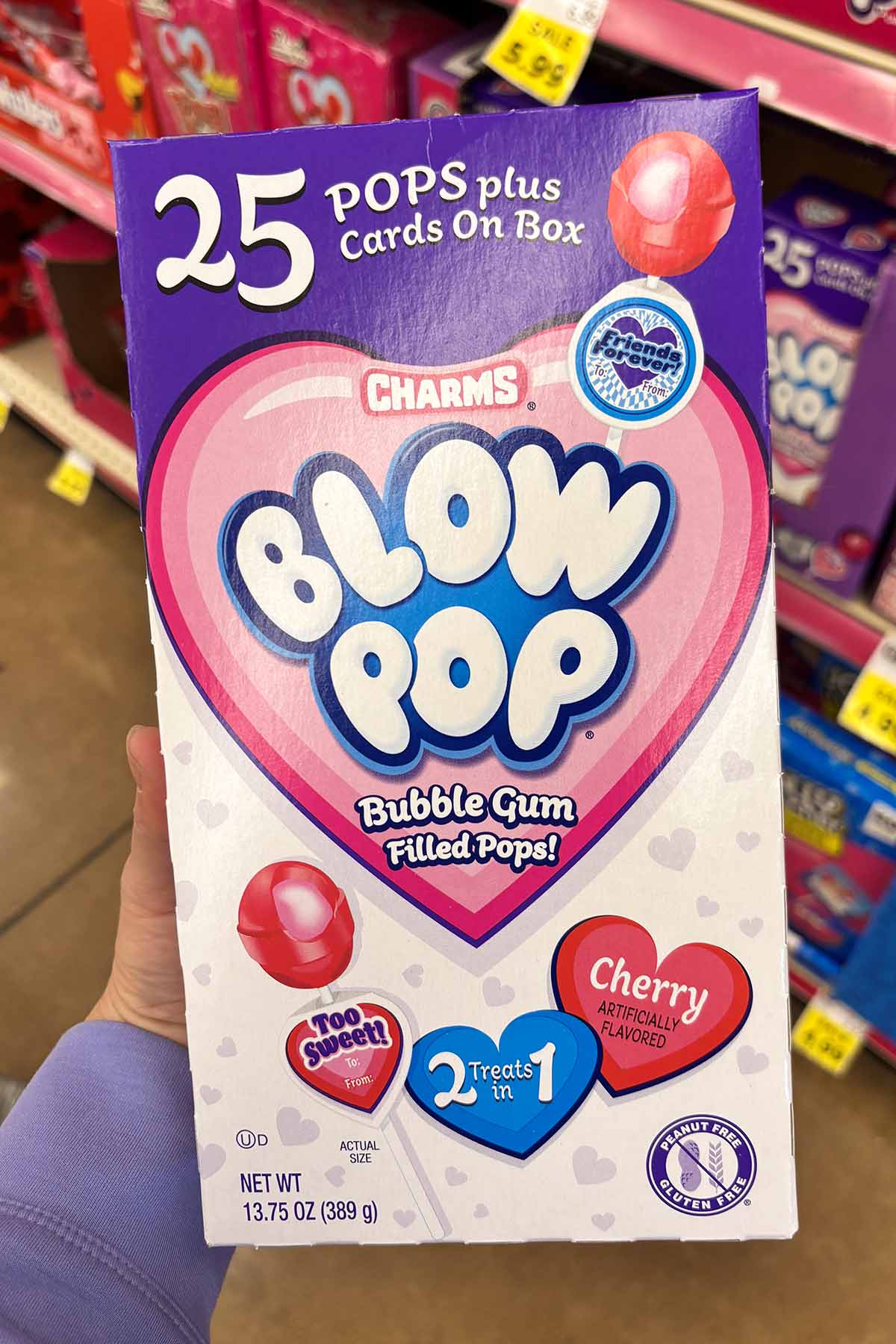 hand holding a box of Blow Pop Valentines in the grocery aisle