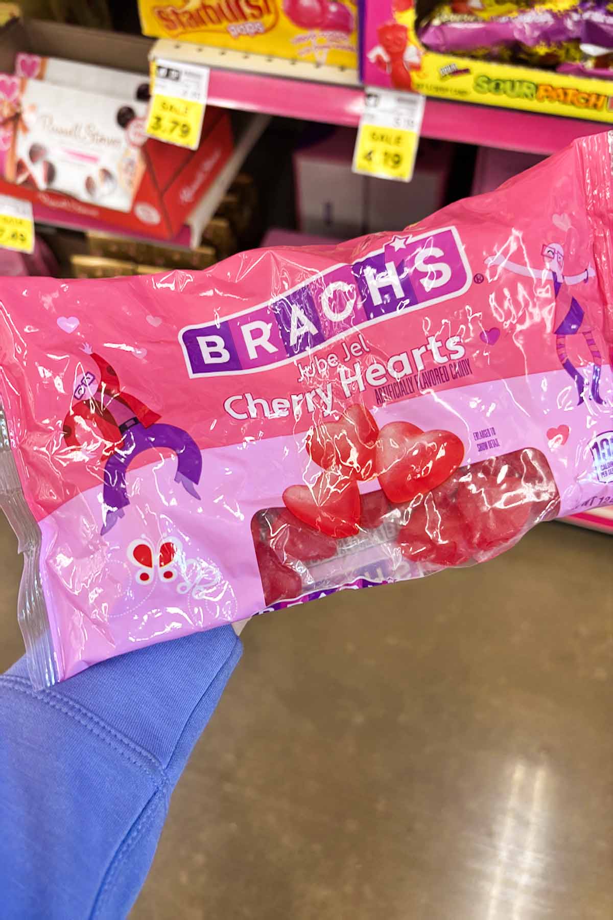 hand holding a package of Brach's Cherry Hearts
