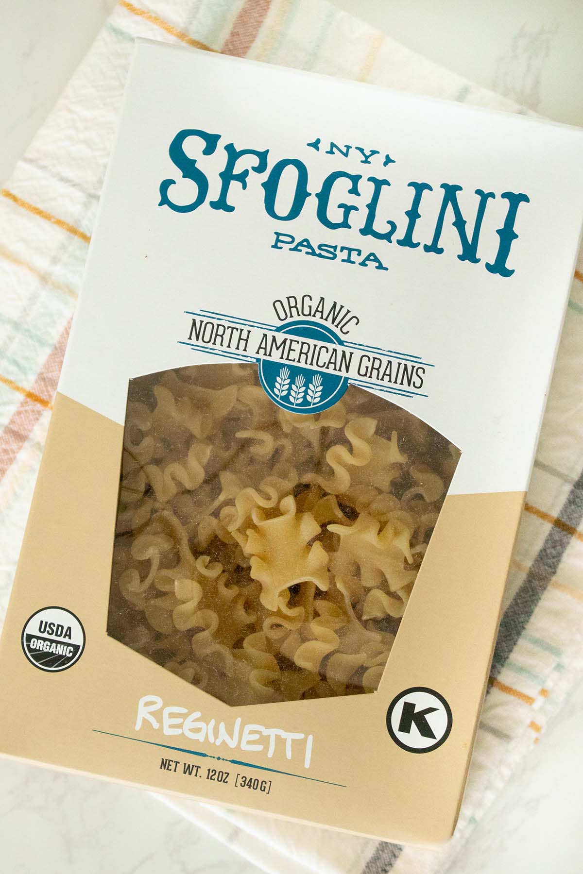 box of Sfoglini Reginetti pasta on a white table