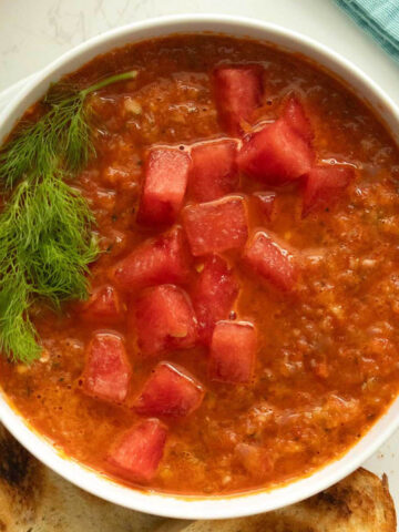 bowl of watermelon gazpacho topped with fennel leaves and chopped watermelon