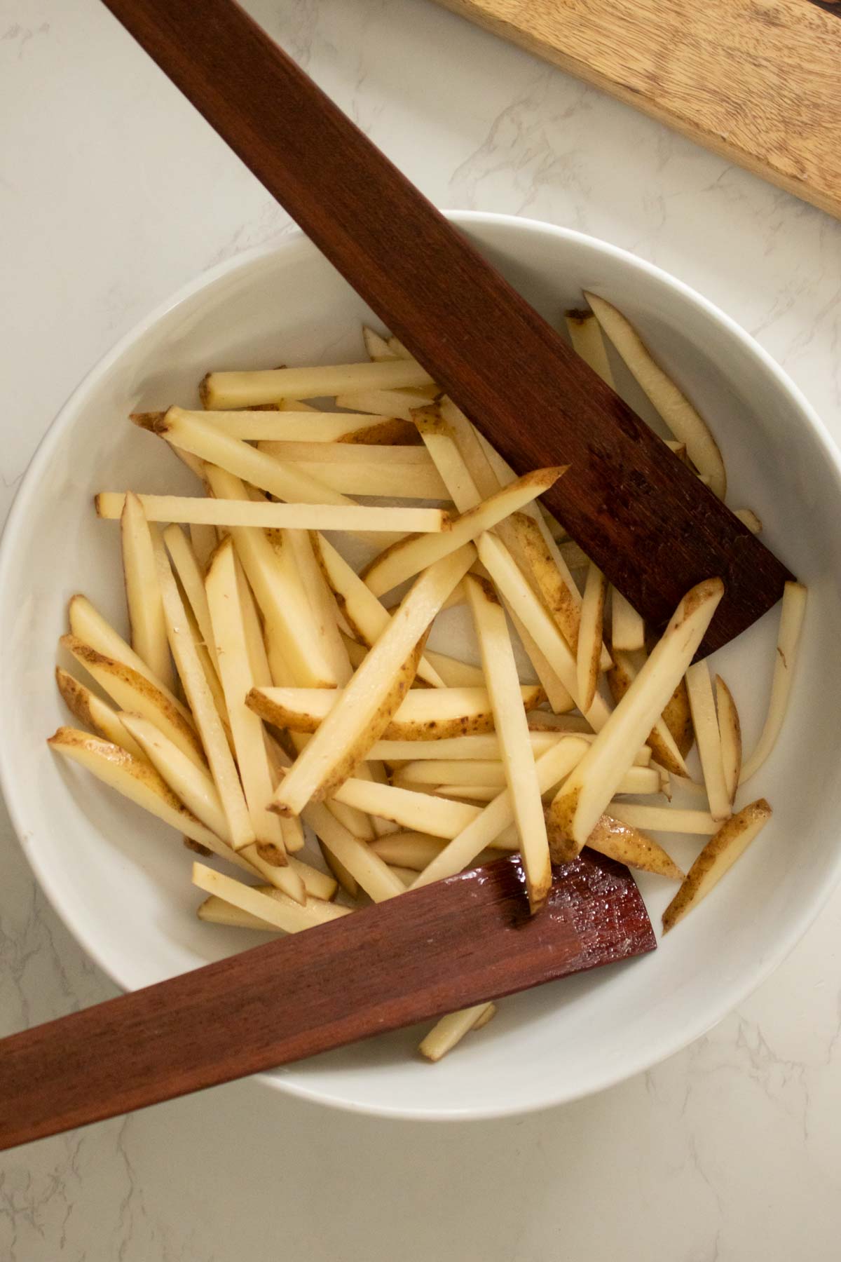 tossing the potato pieces with oil