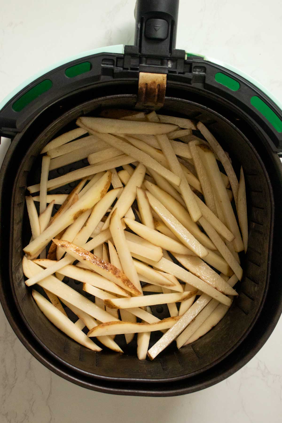 potato pieces in the air fryer before cooking