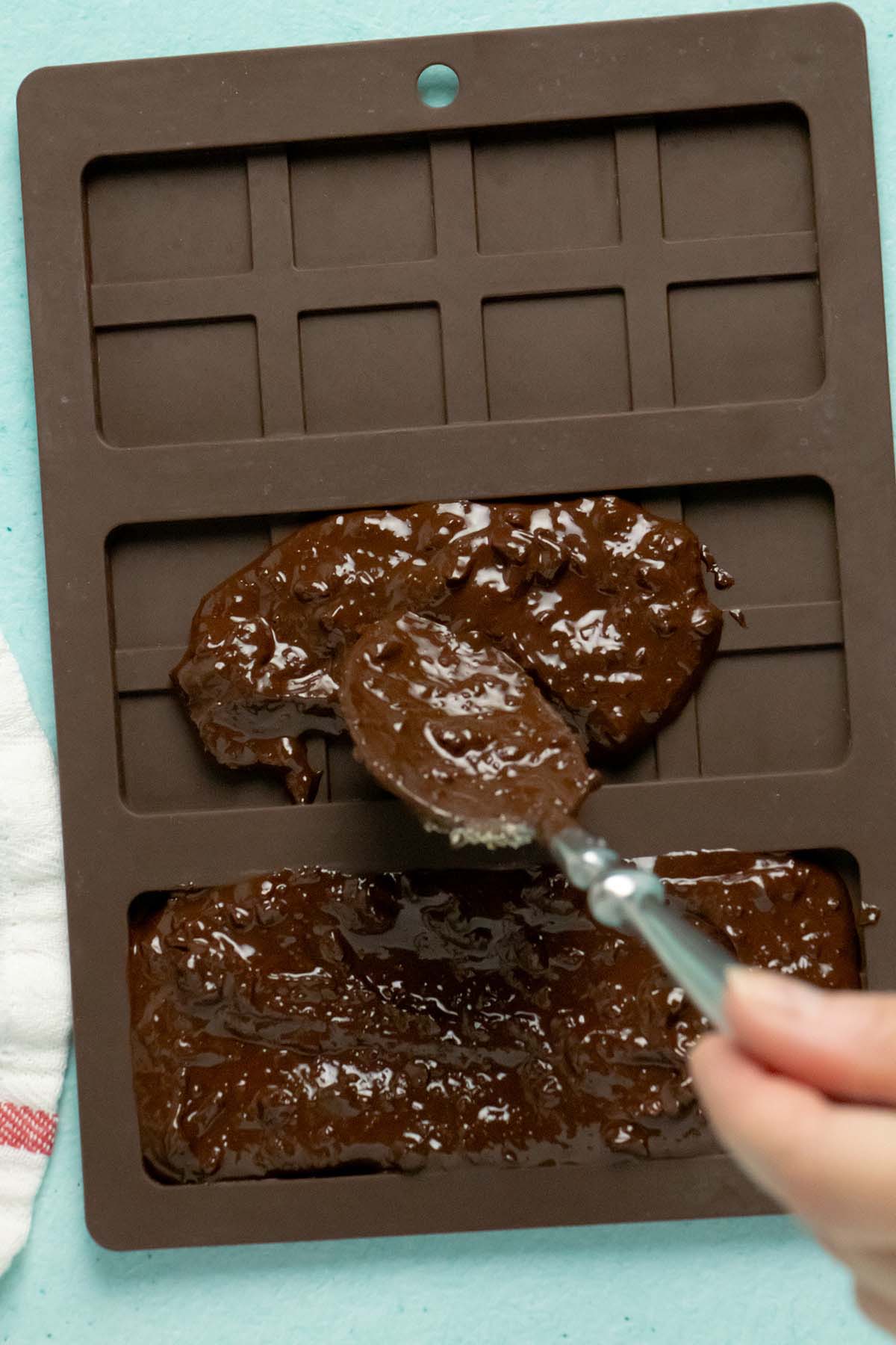 spooning chocolate into the chocolate bar molds
