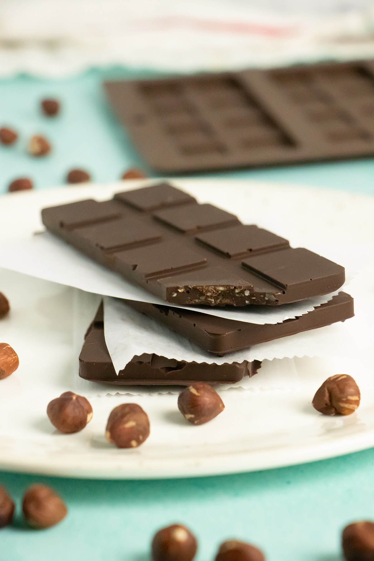 stack of vegan crunch bars on parchment paper with a bite out of one bar