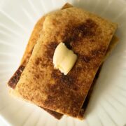snickerdoodle pancakes on the plate topped with a pat of vegan butter