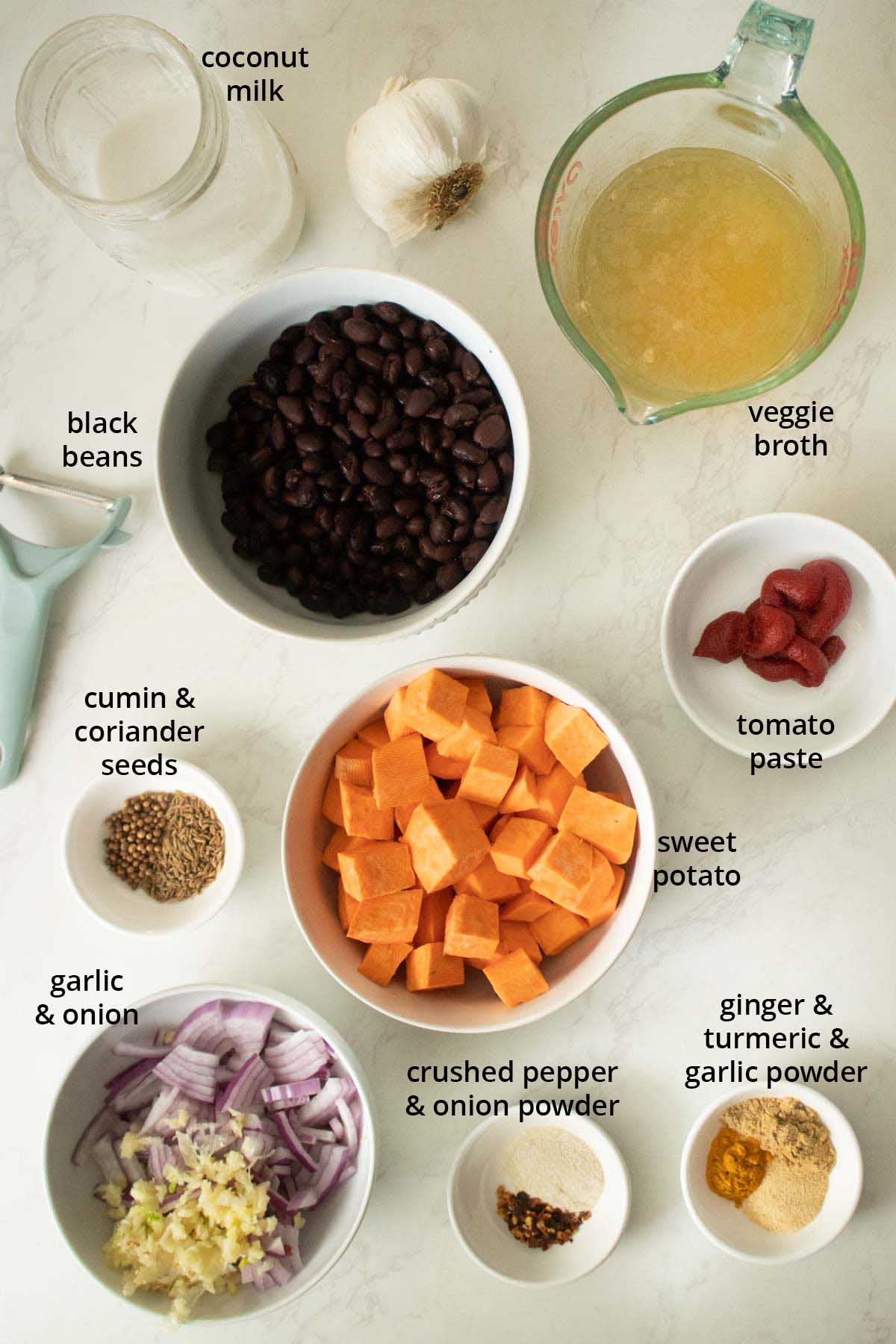 black bean sweet potato soup ingredients in bowls open a white table, text labels