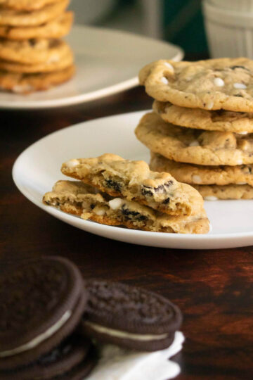 cookies and cream cookies on plates with a cookie broken in half, so you can see the inside
