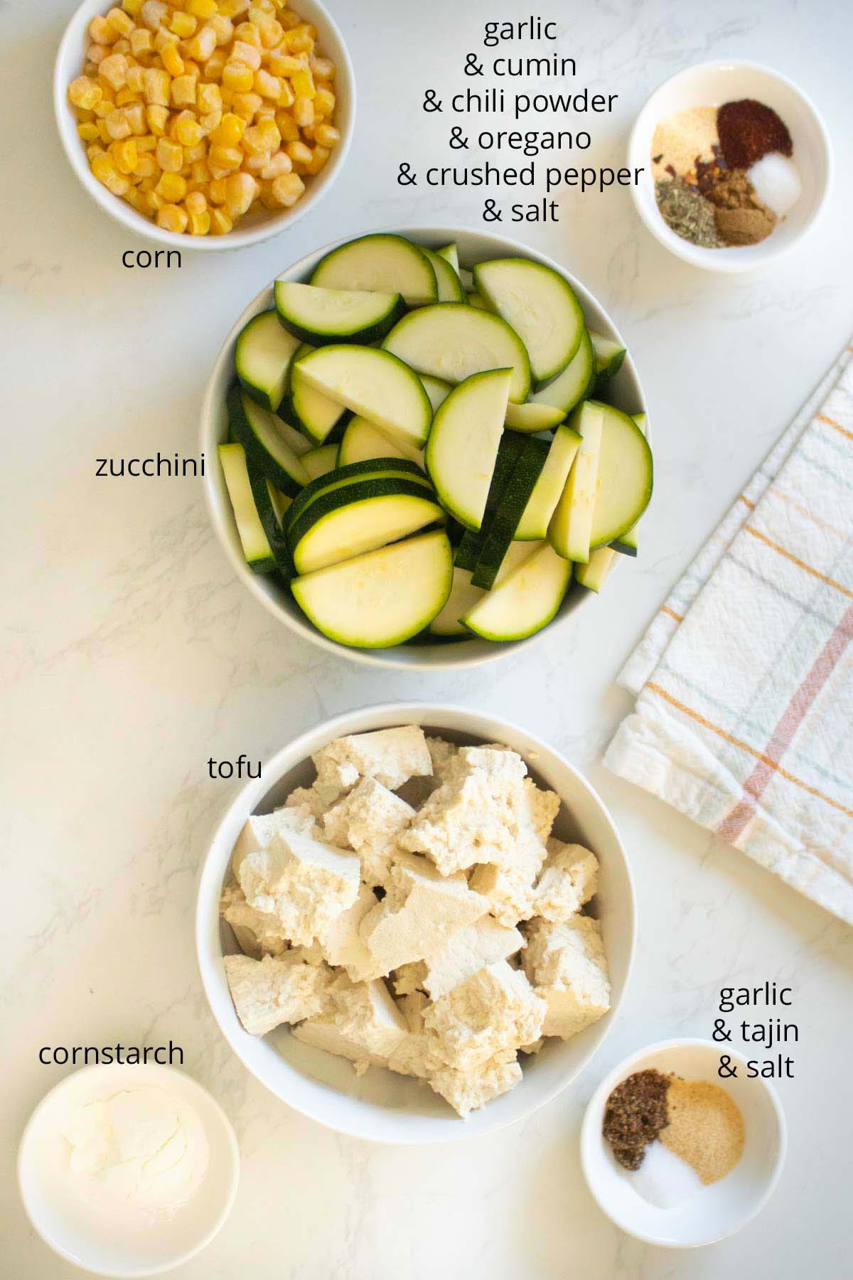 mexican inspired crispy tofu bowl ingredients on a white countertop, text labels