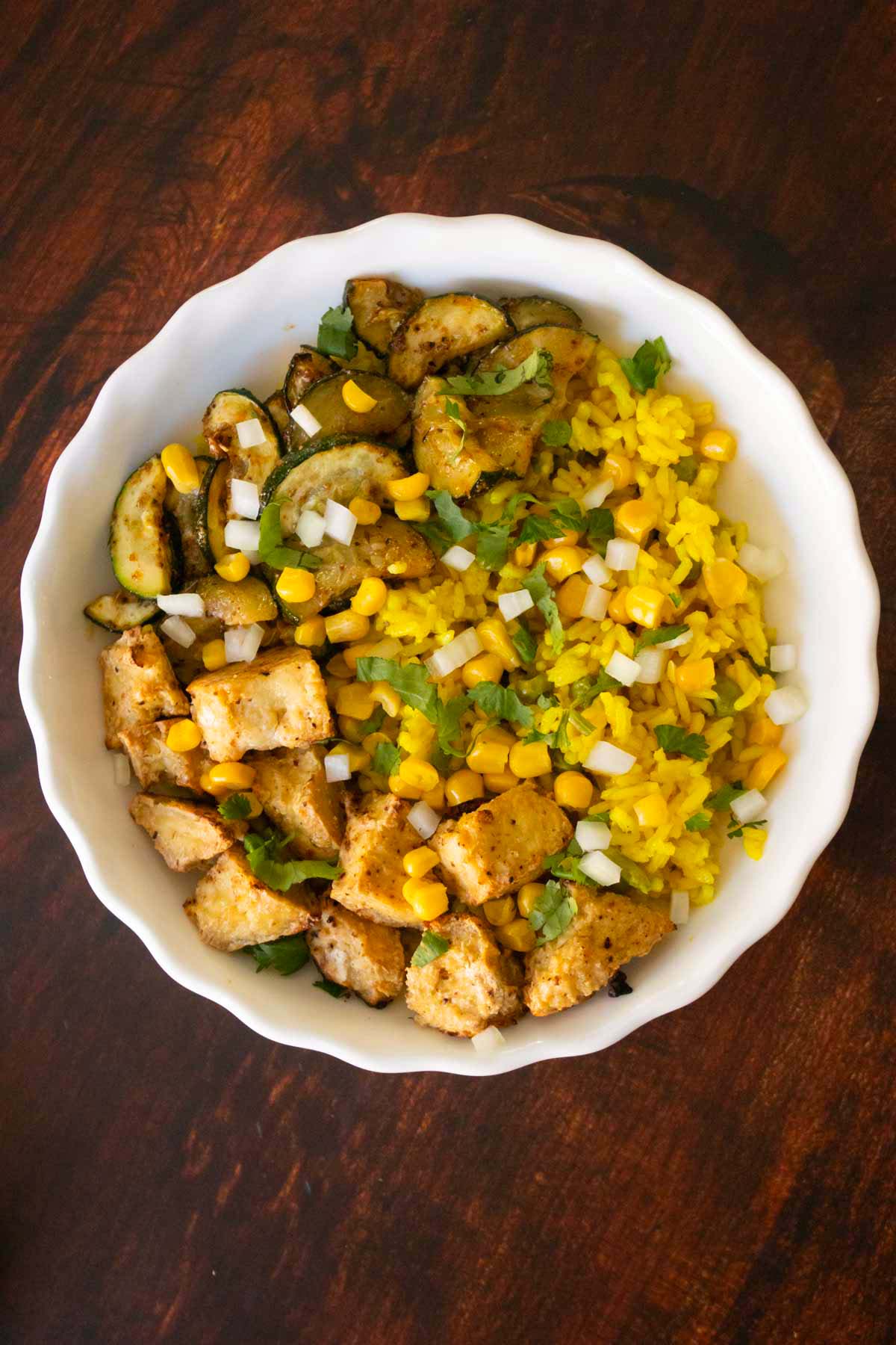 adding corn and onions to the bowl