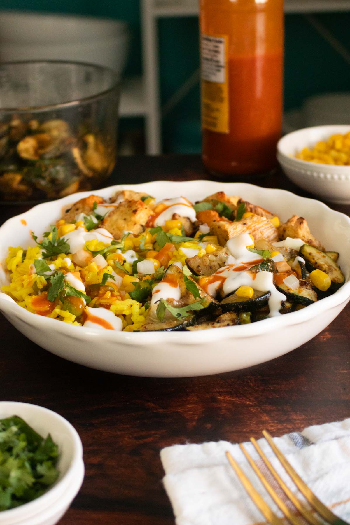Mexican-inspired crispy tofu bowl with toppings containers in the background