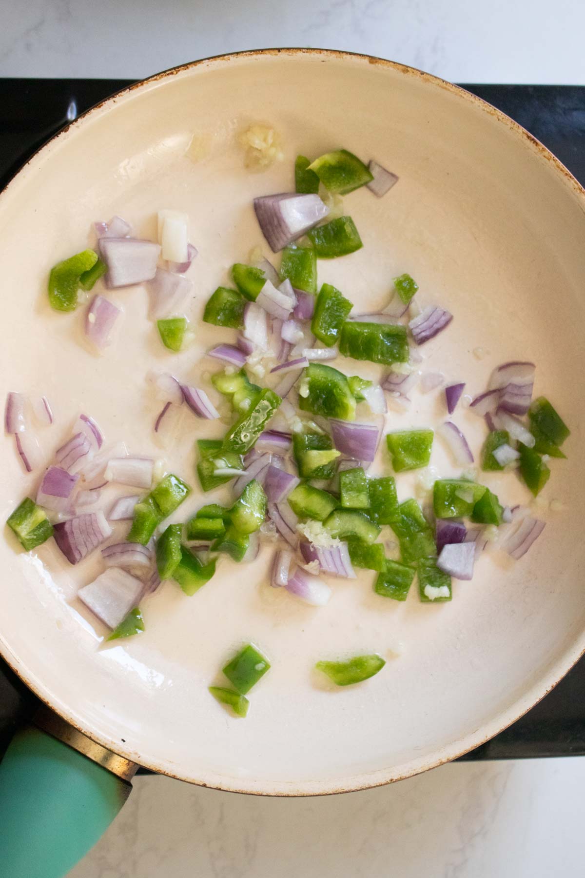 peppers and onions in the pan before cooking