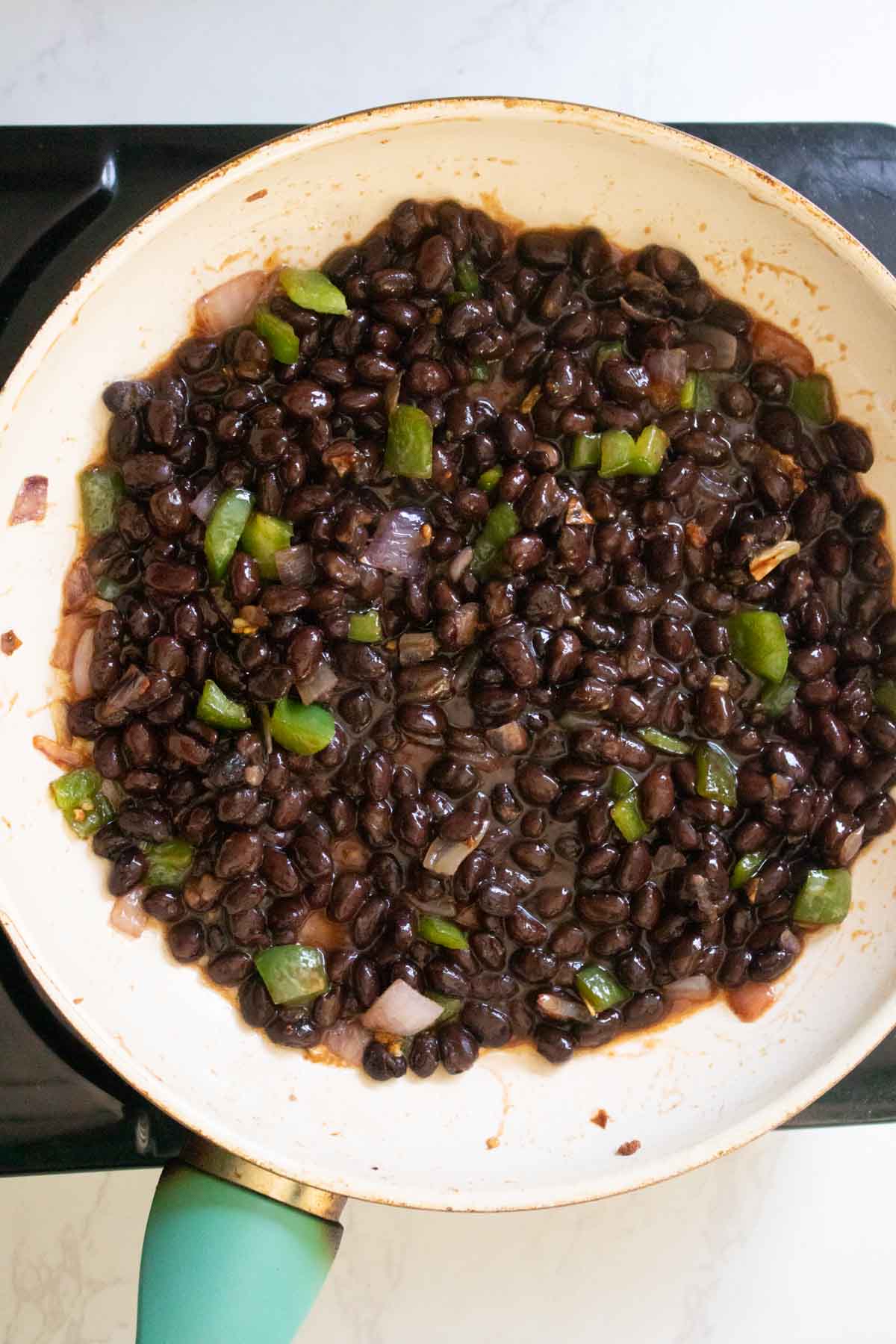 adding black beans and BBQ sauce to the pan