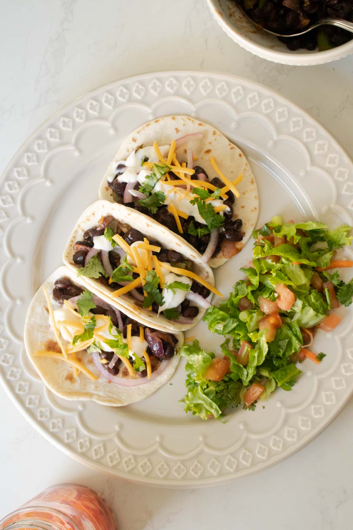 vegan black bean tacos with toppings and a side salad