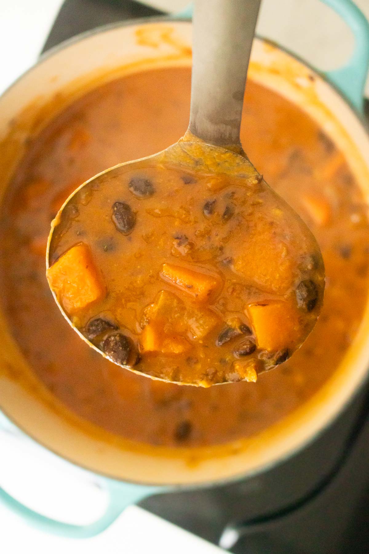 ladle serving some black bean sweet potato soup