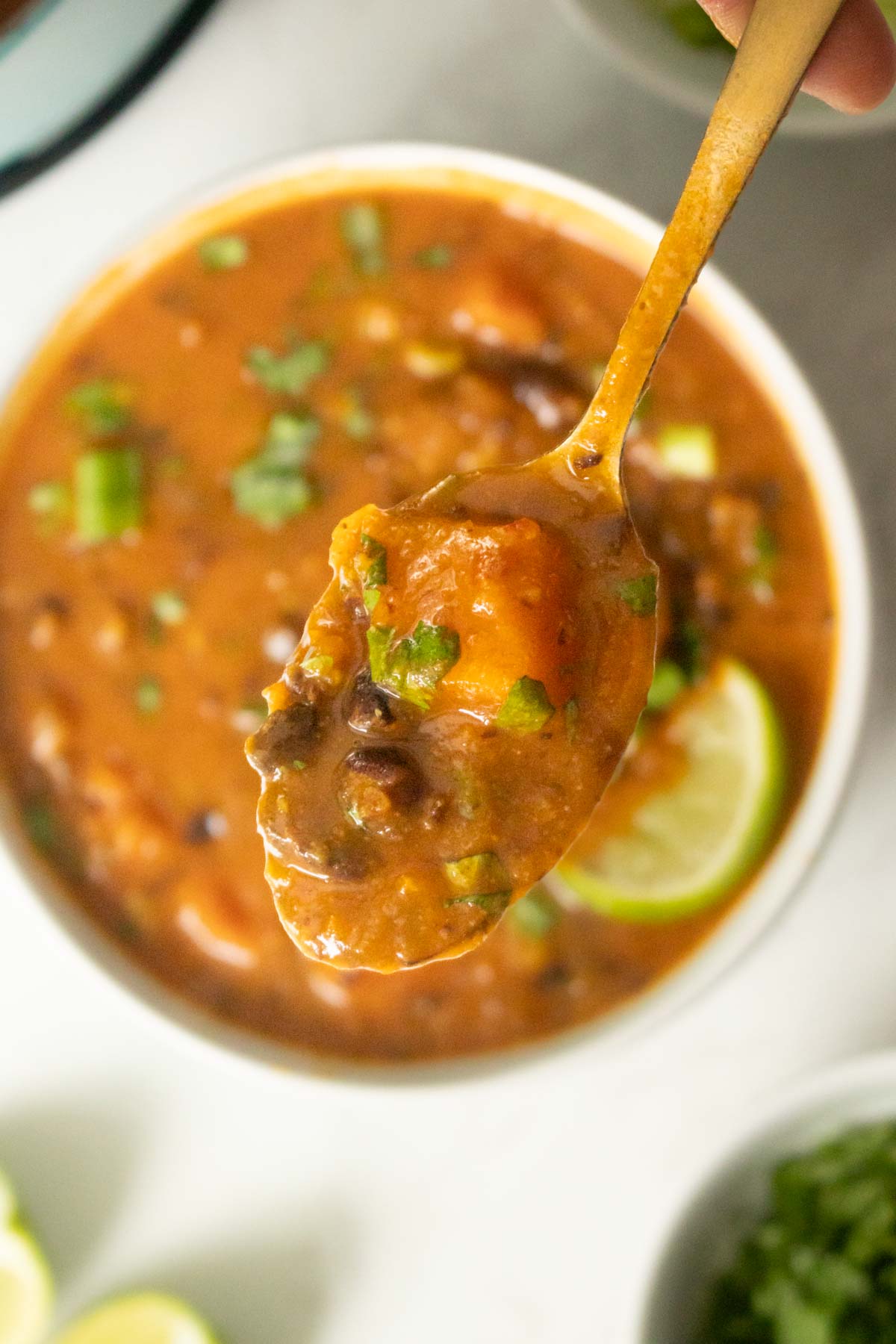 spoon taking a bite of black bean sweet potato soup