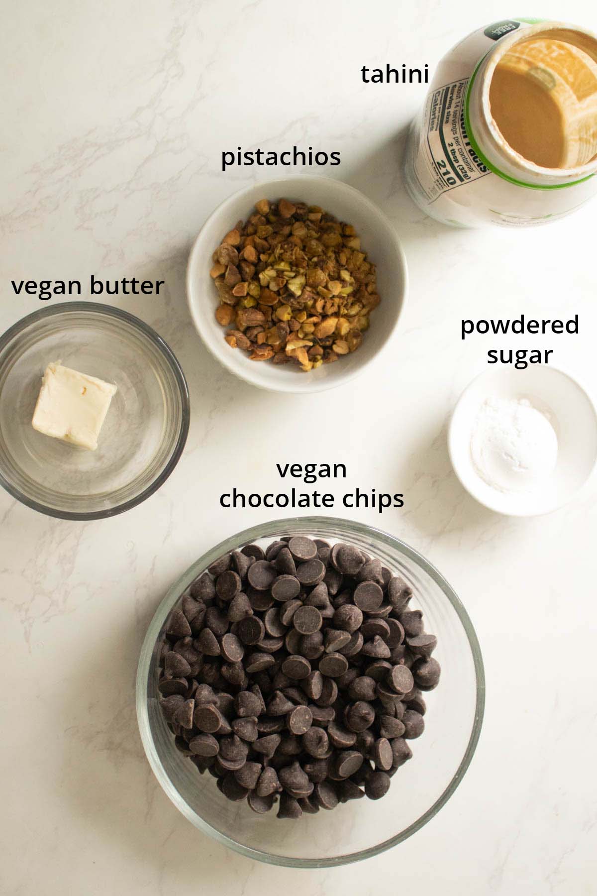 chocolate pistachio bark ingredients in bowls on a table, text labels