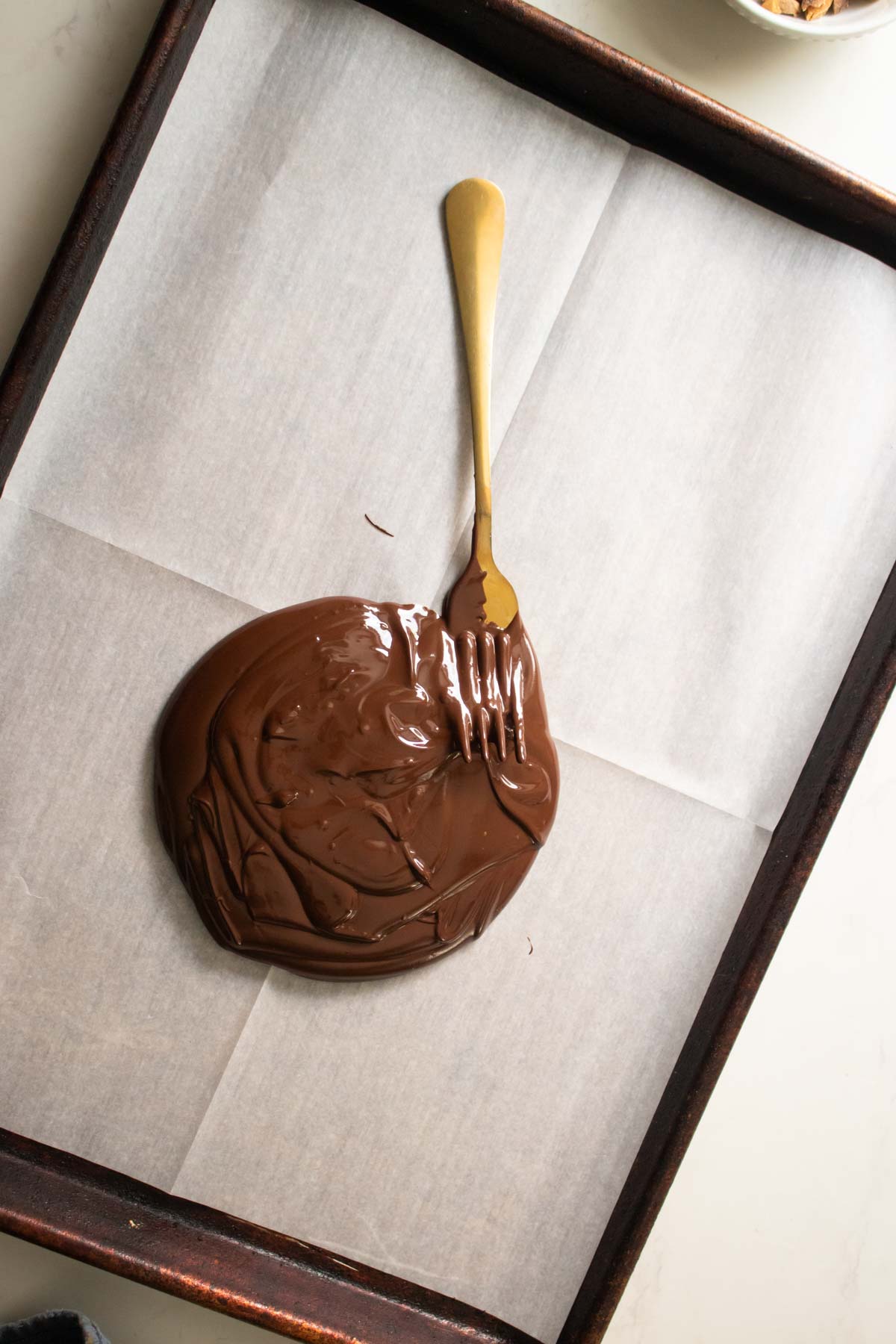 pouring melted chocolate onto the baking sheet