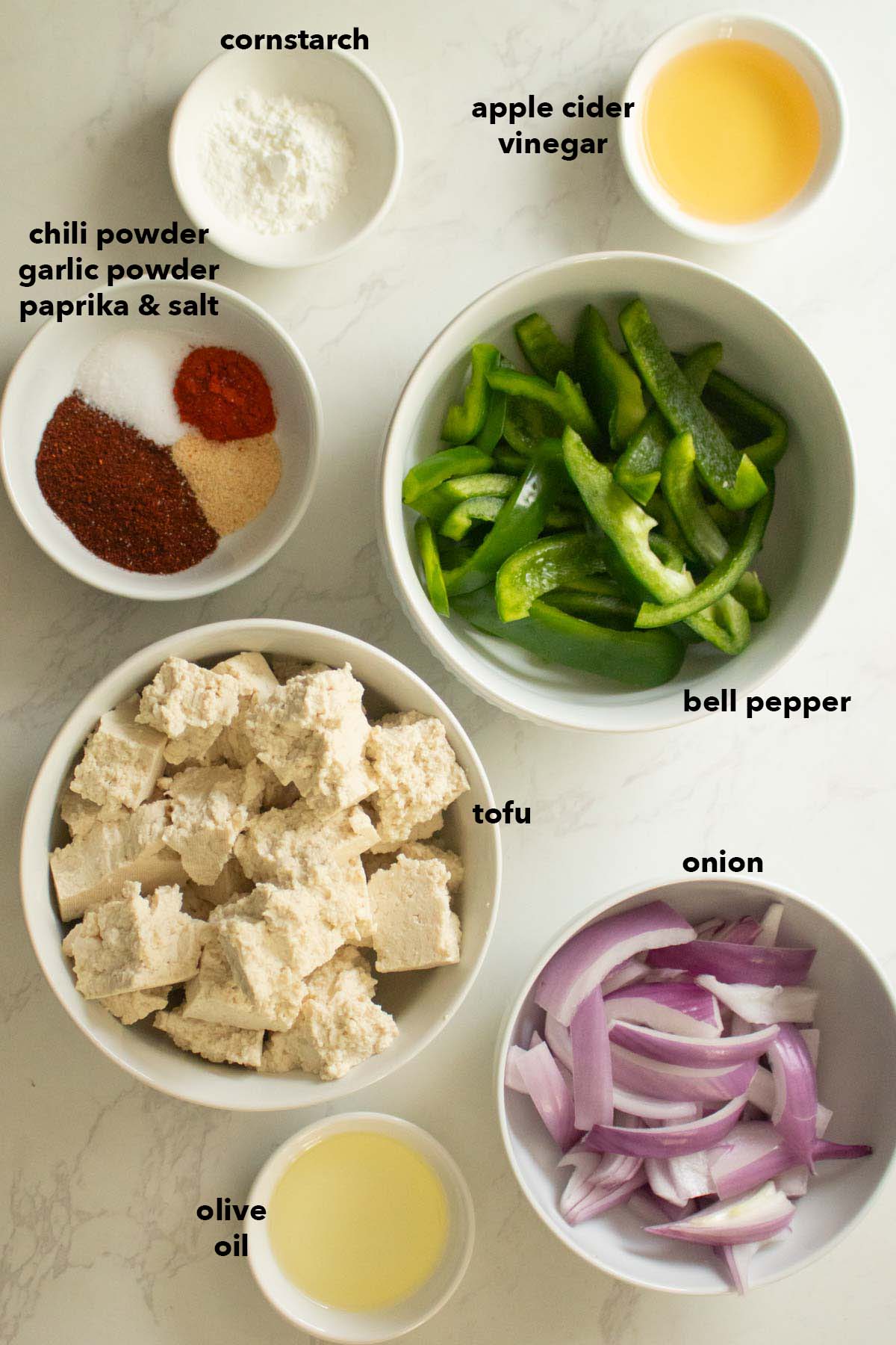 vegan fajita bowl ingredients in bowls on a white table
