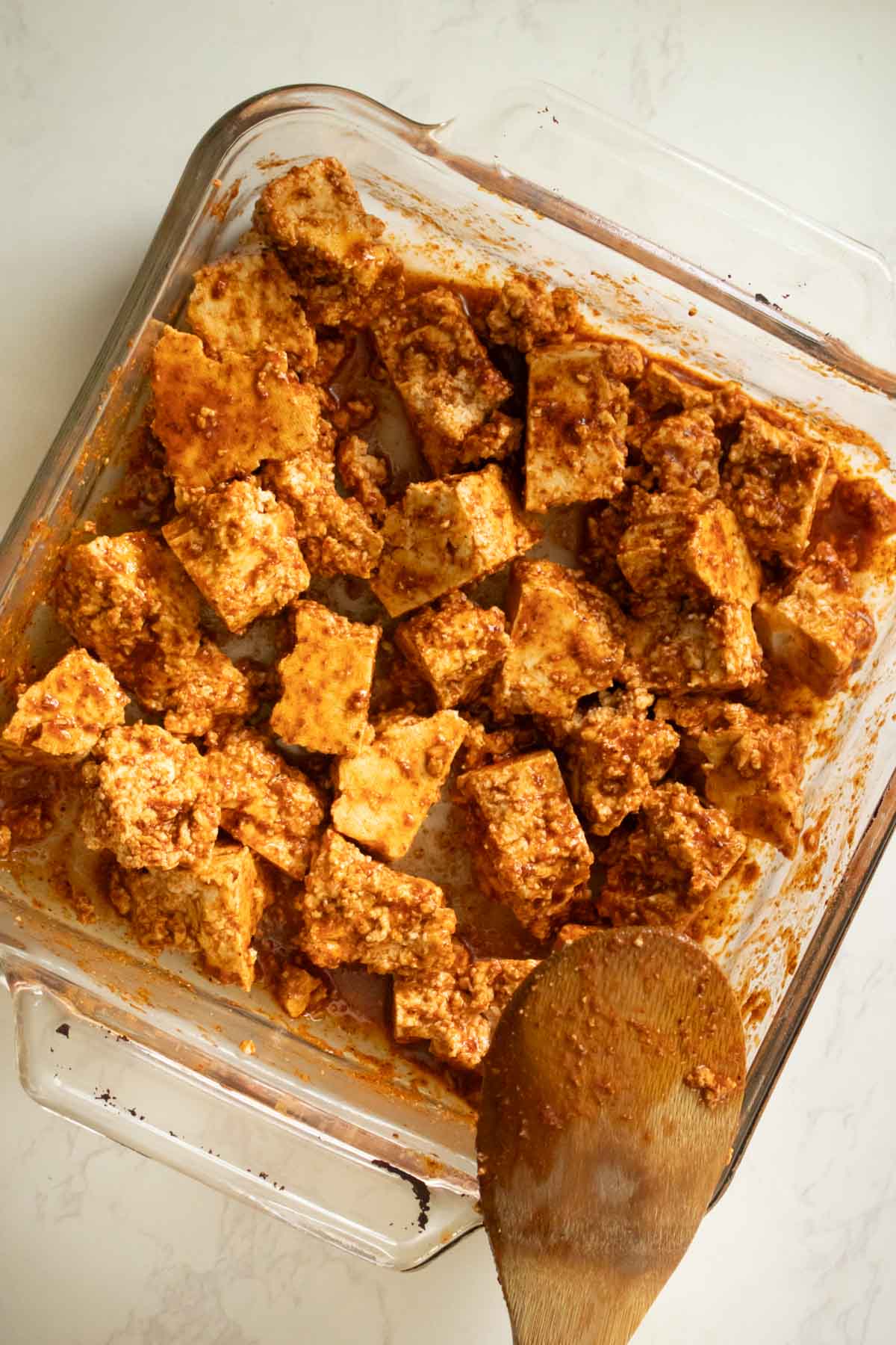 tofu tossed in marinade in the baking pan