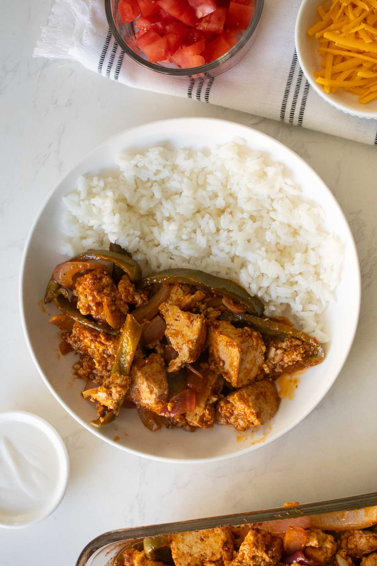 adding the tofu and fajita veggies to the bowl