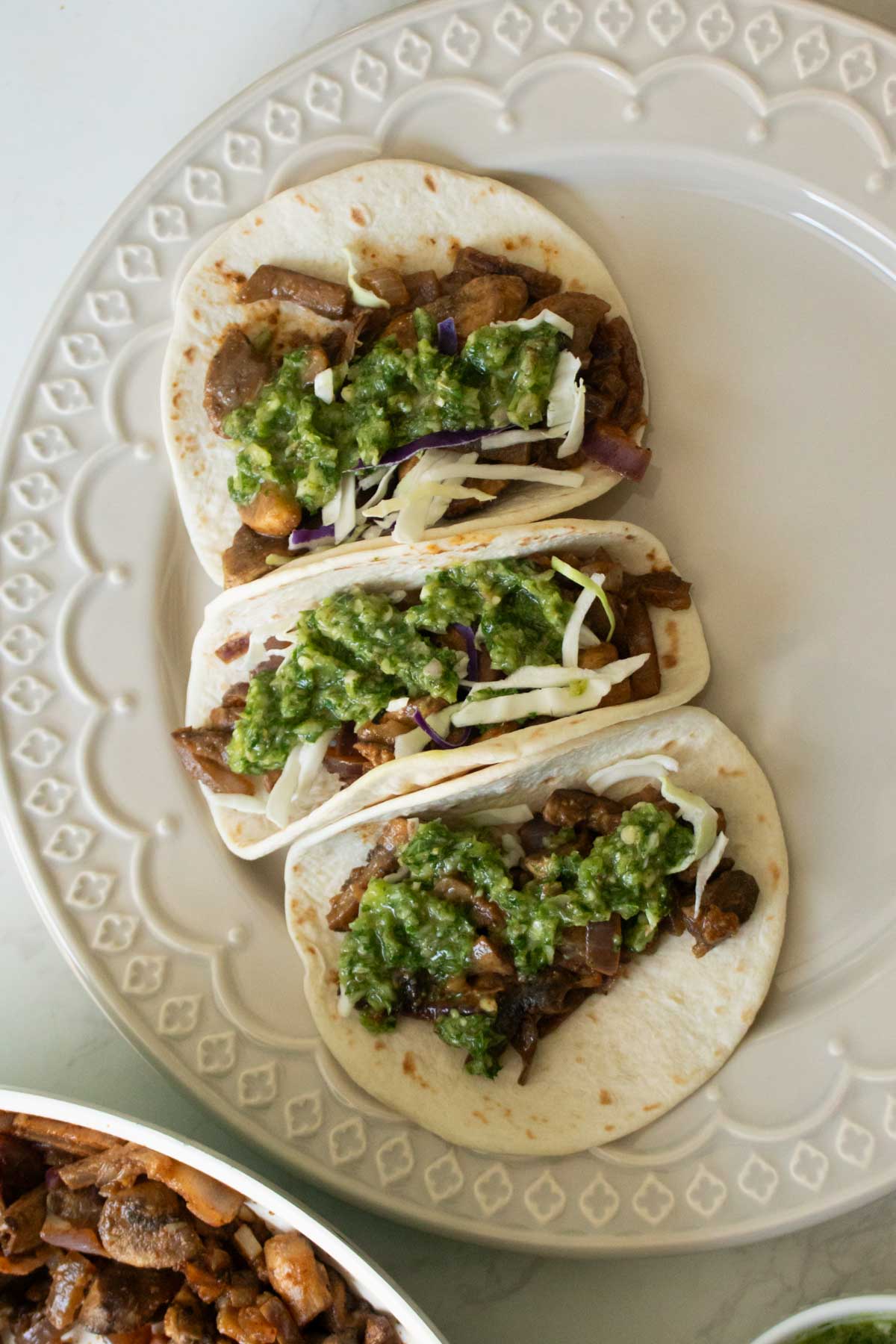 adding chimichurri to the mushroom tacos