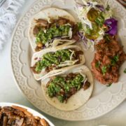 mushroom tacos on a gray plate with refried beans and a salad