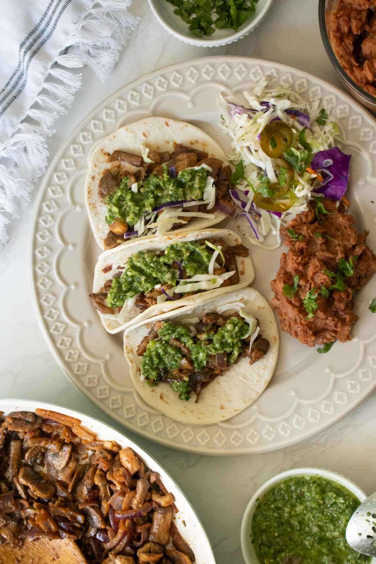 mushroom tacos on a gray plate with refried beans and a salad