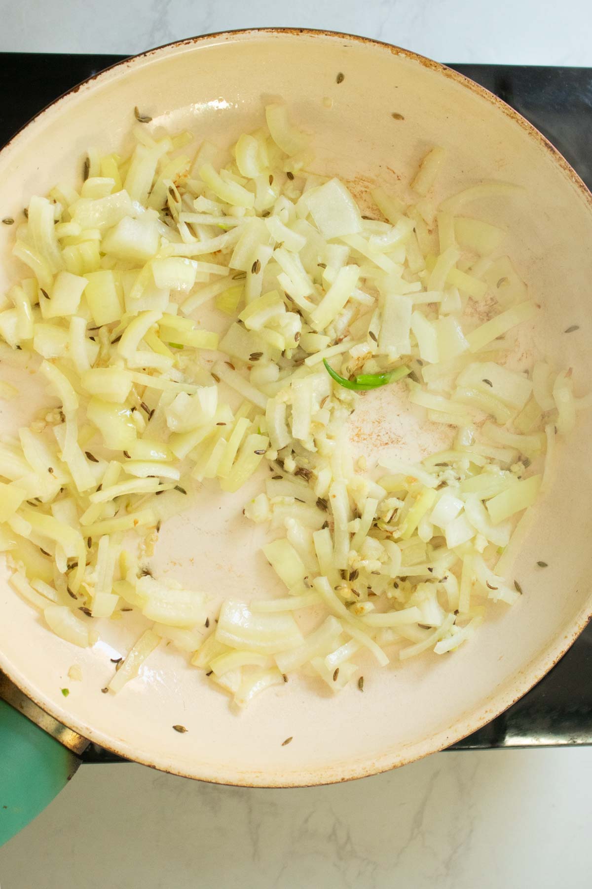 adding onion and garlic to the pan