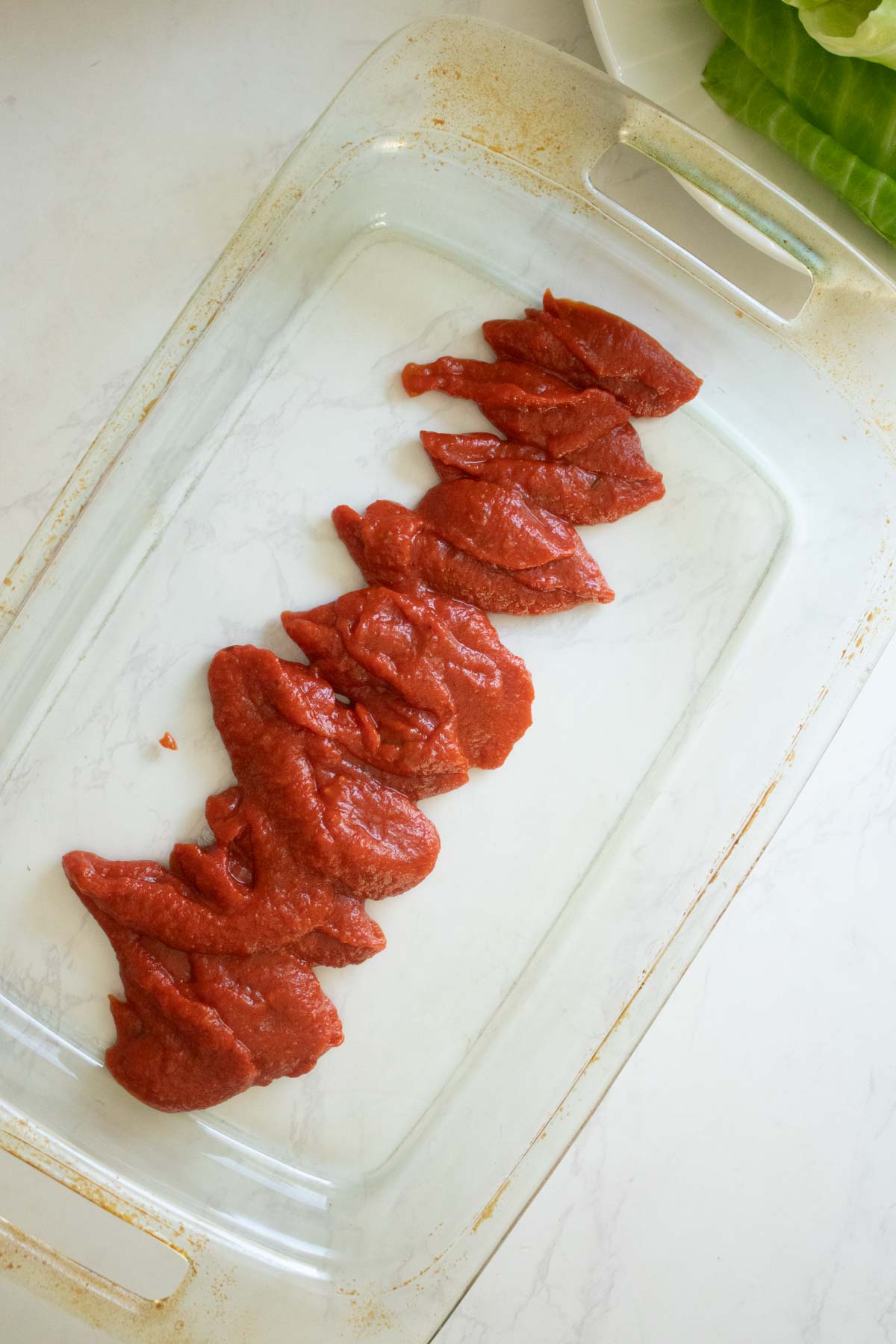 tomato sauce in the bottom of the pan before spreading