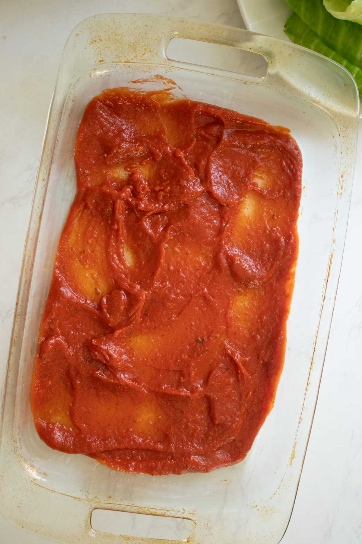 tomato sauce in the bottom of the pan after spreading