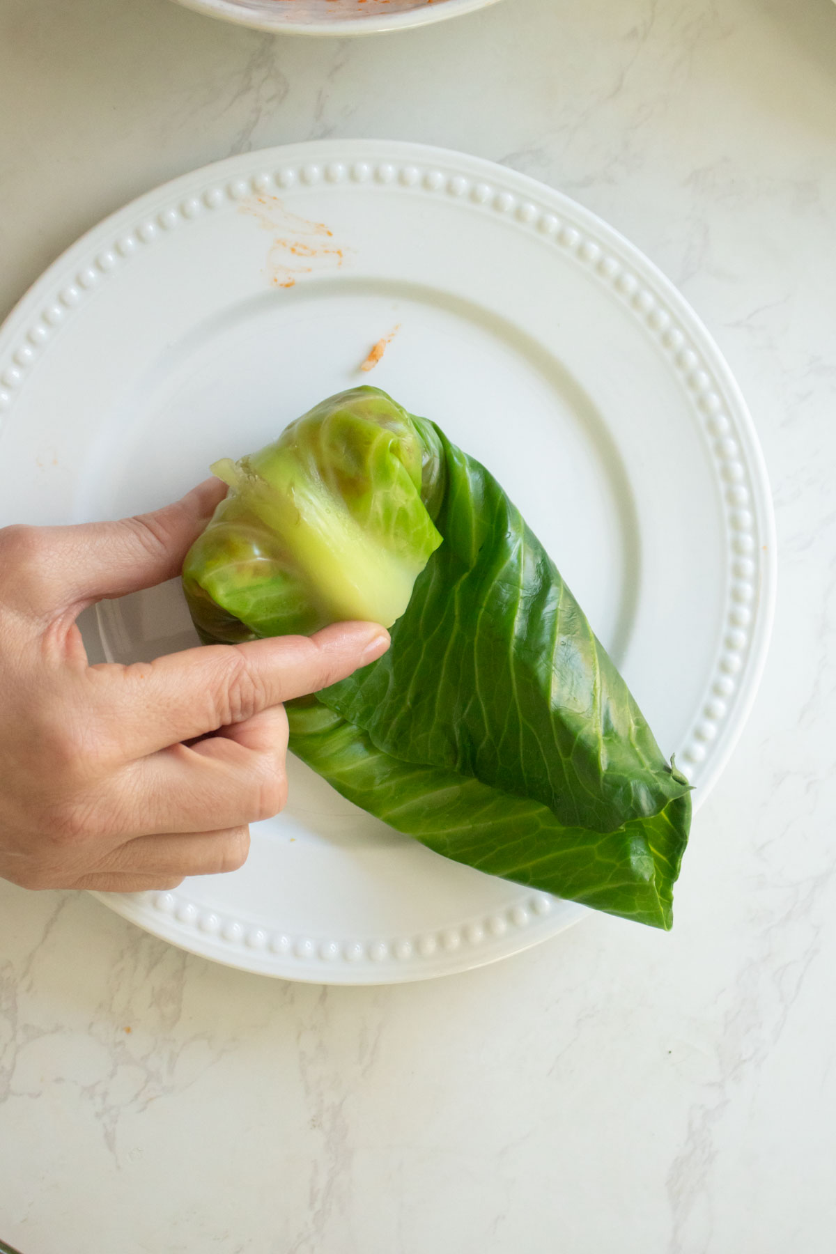 rolling the cabbage leaf up with the filling inside