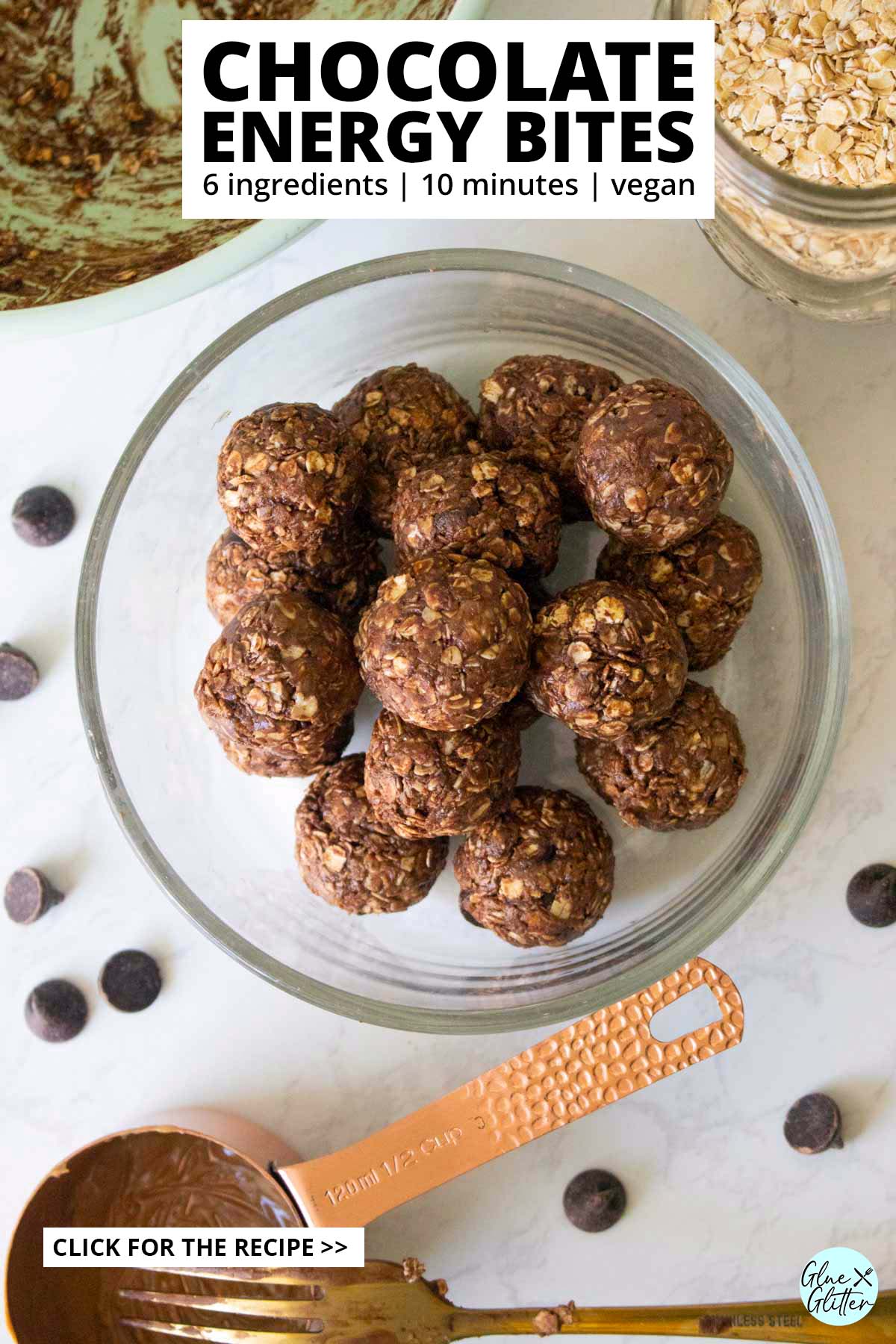 chocolate energy bites in a glass bowl with the mixing bowl and ingredients around it