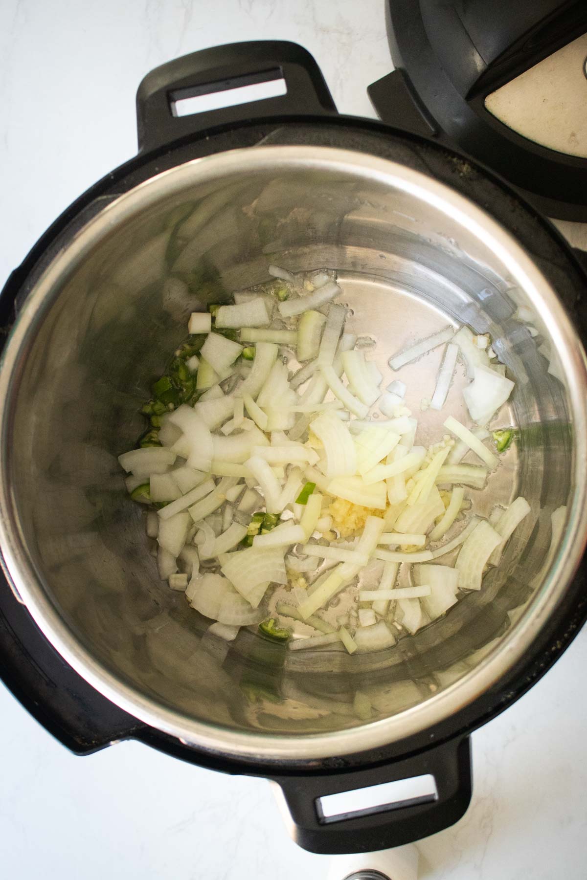 onions, garlic, and chili in the pot before cooking
