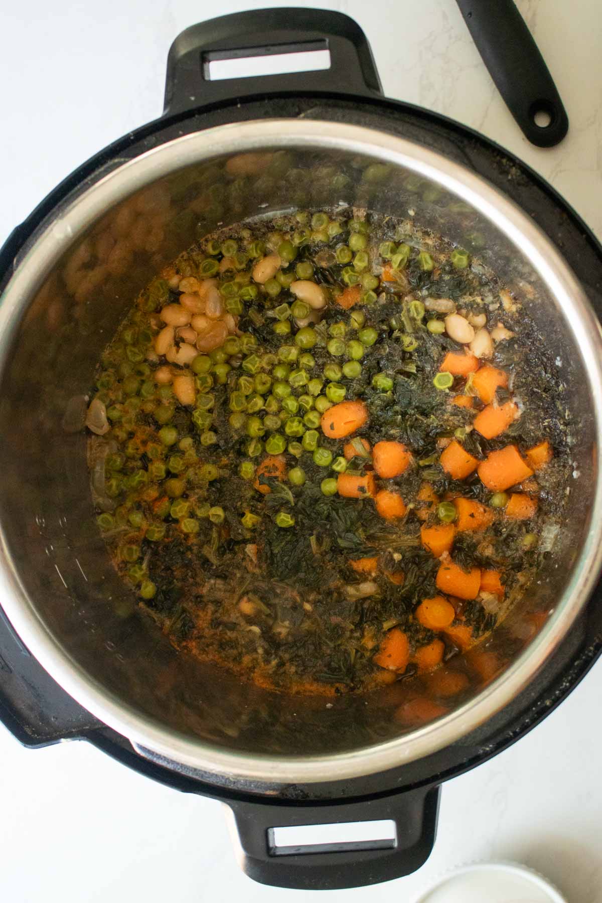 Instant Pot white bean soup in the pot before stirring