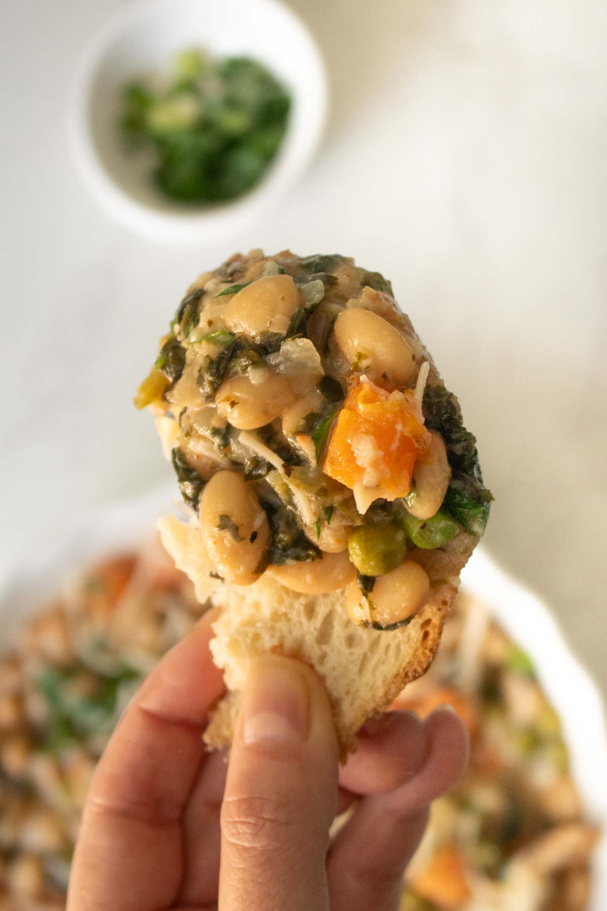 close up of a piece of bread with white bean stew on it