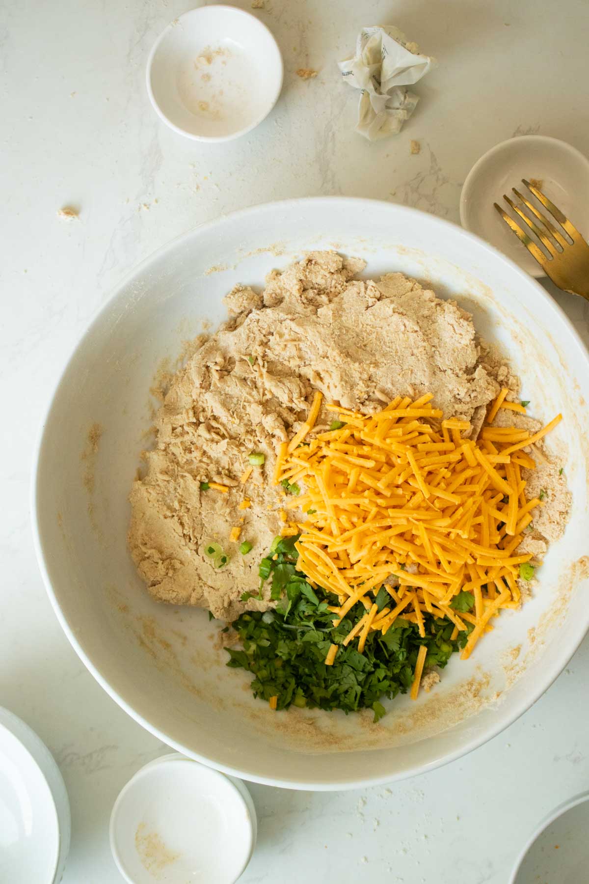 adding cheese and herbs to savory vegan scones dough