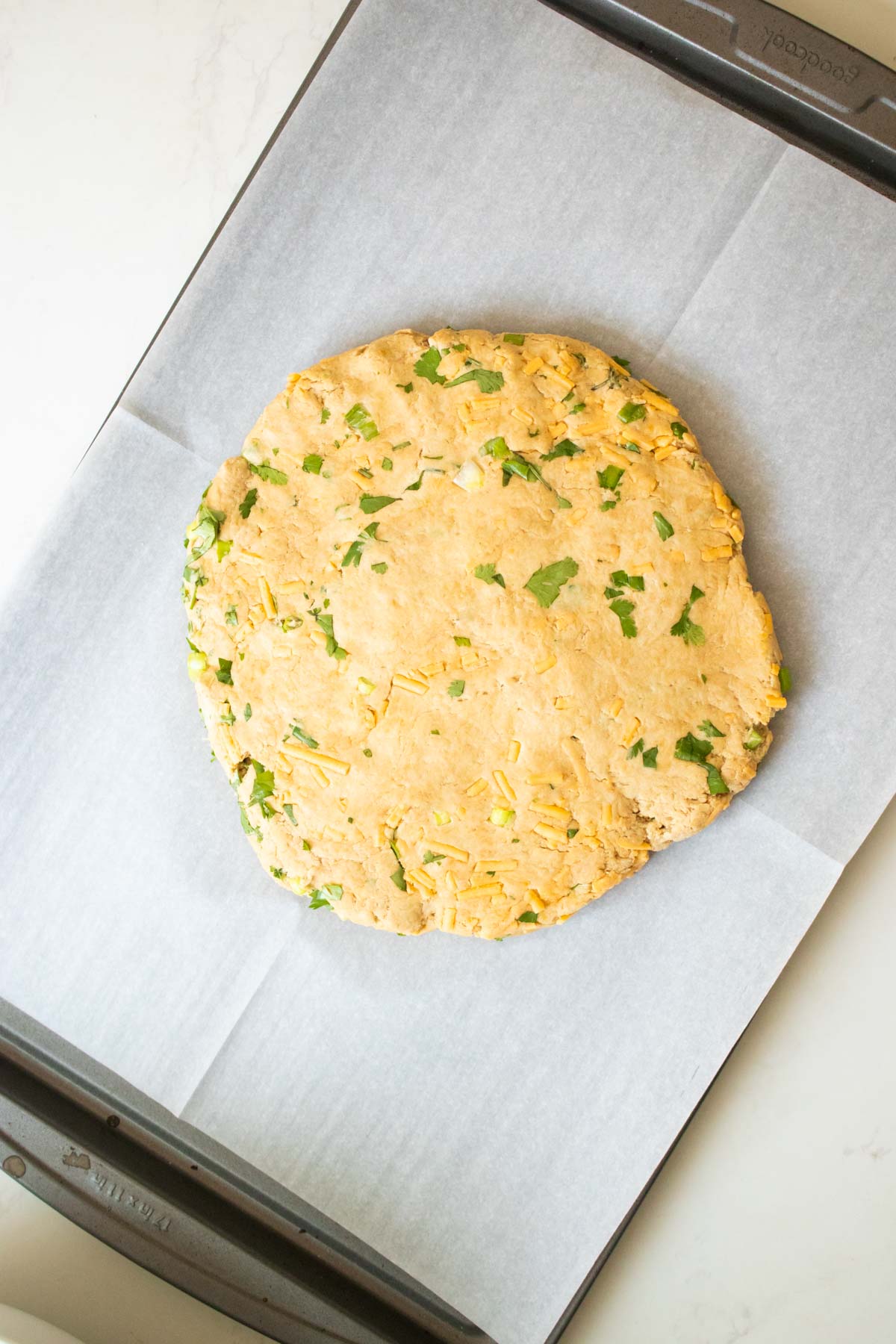 savory vegan scones dough flattened on the baking sheet