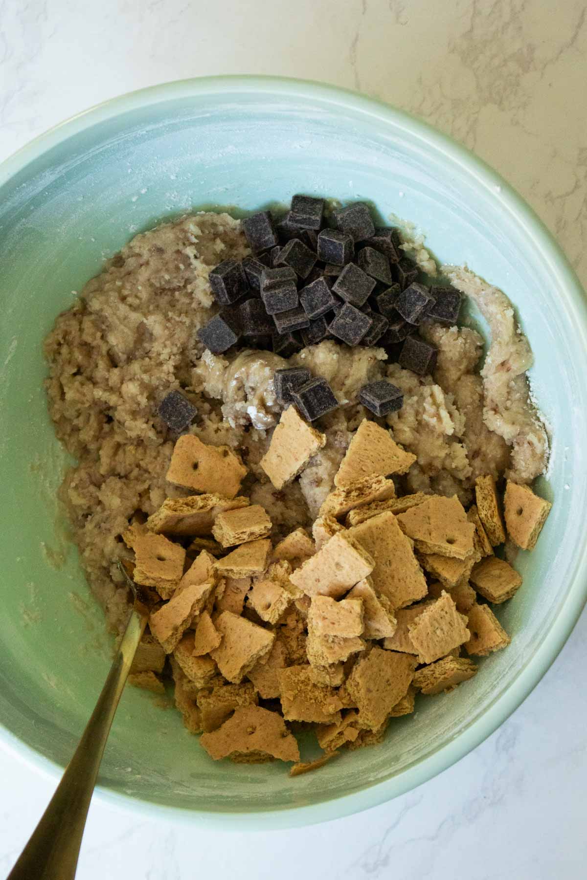 adding vegan chocolate chunks and graham cracker pieces to the dough