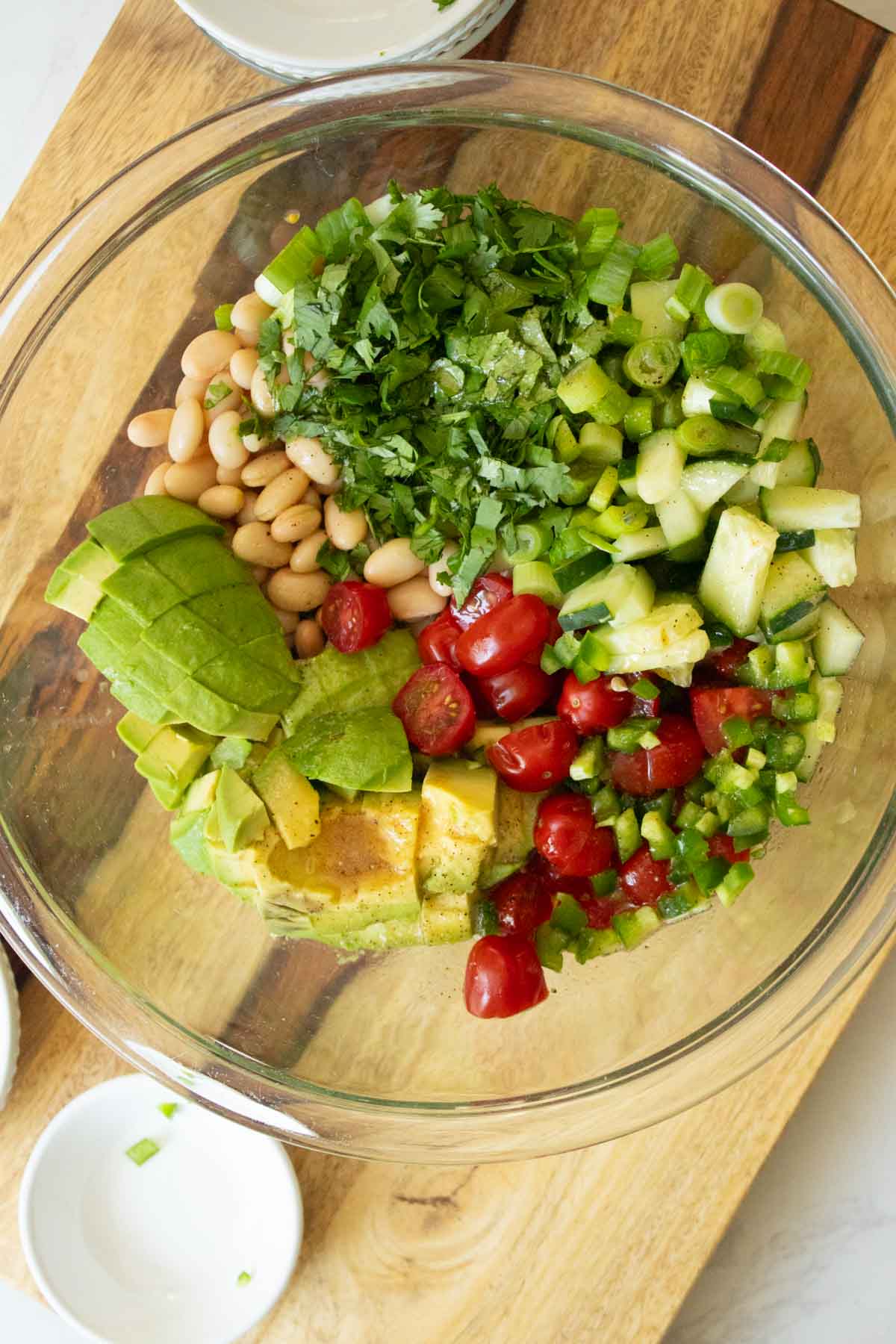 avocado white bean salad ingredients in the mixing bowl bowl after adding dressing