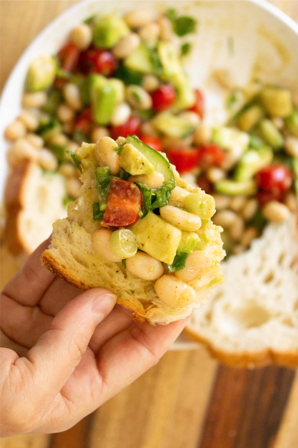 bread with a scoop of avocado white bean salad on in