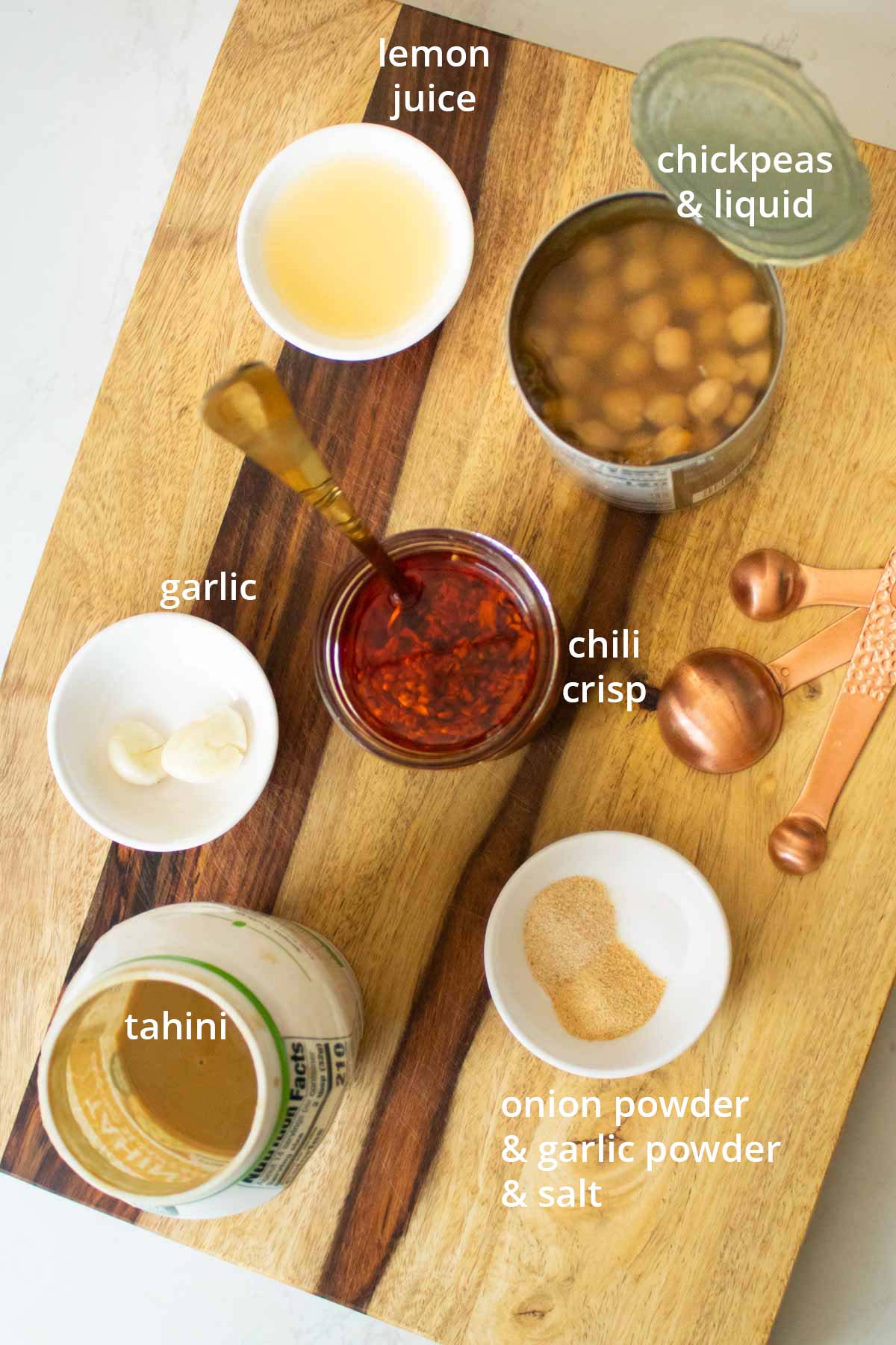 chili crisp hummus ingredients on a wooden cutting board