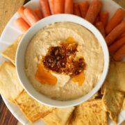 serving platter with chili crisp hummus, pita chips, and baby carrots