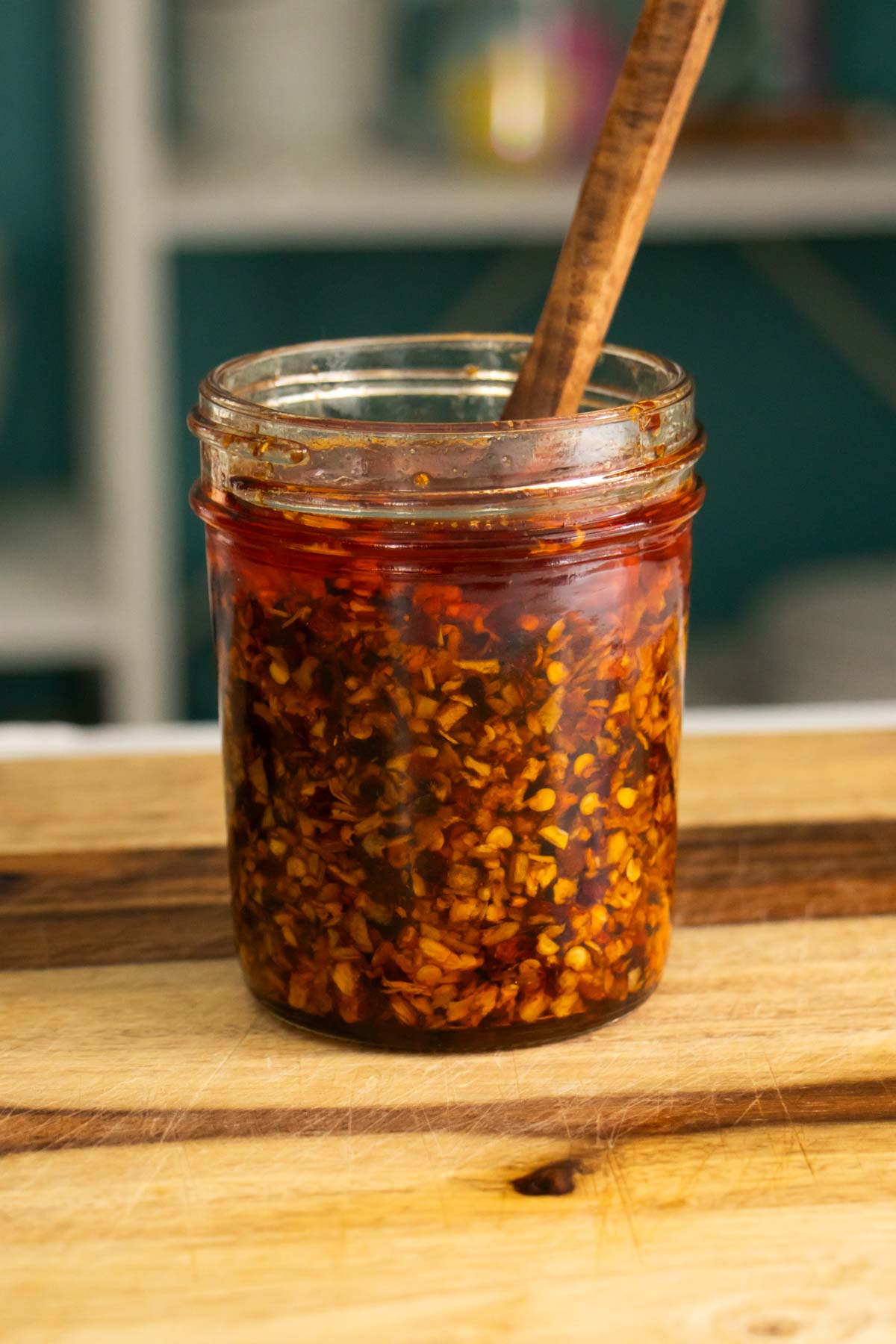 jar of chili onion crunch with a wooden spoon in it